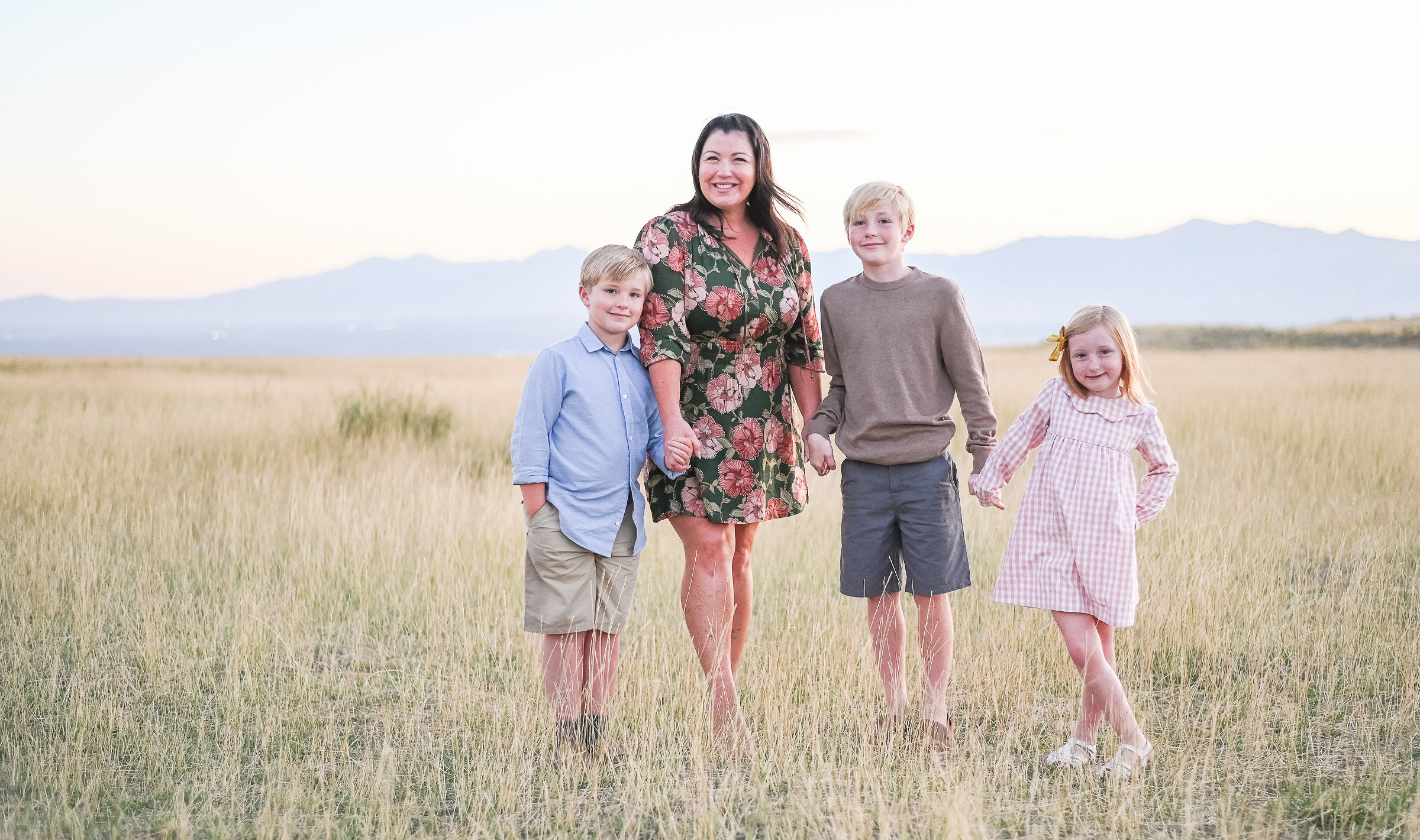 Family walking through the tall grass at Tunnel Springs Park in Utah.