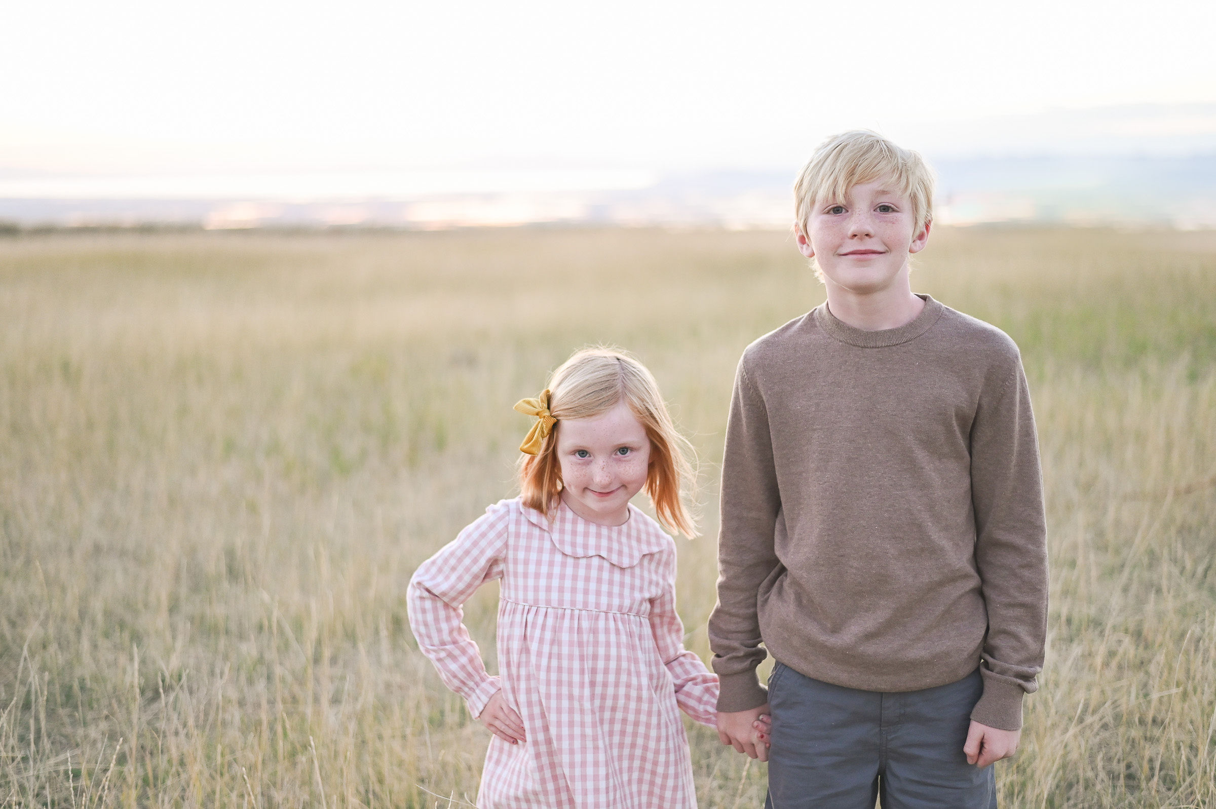 Brother and sister holding hands at Tunnel Springs Park in Utah at sunset.