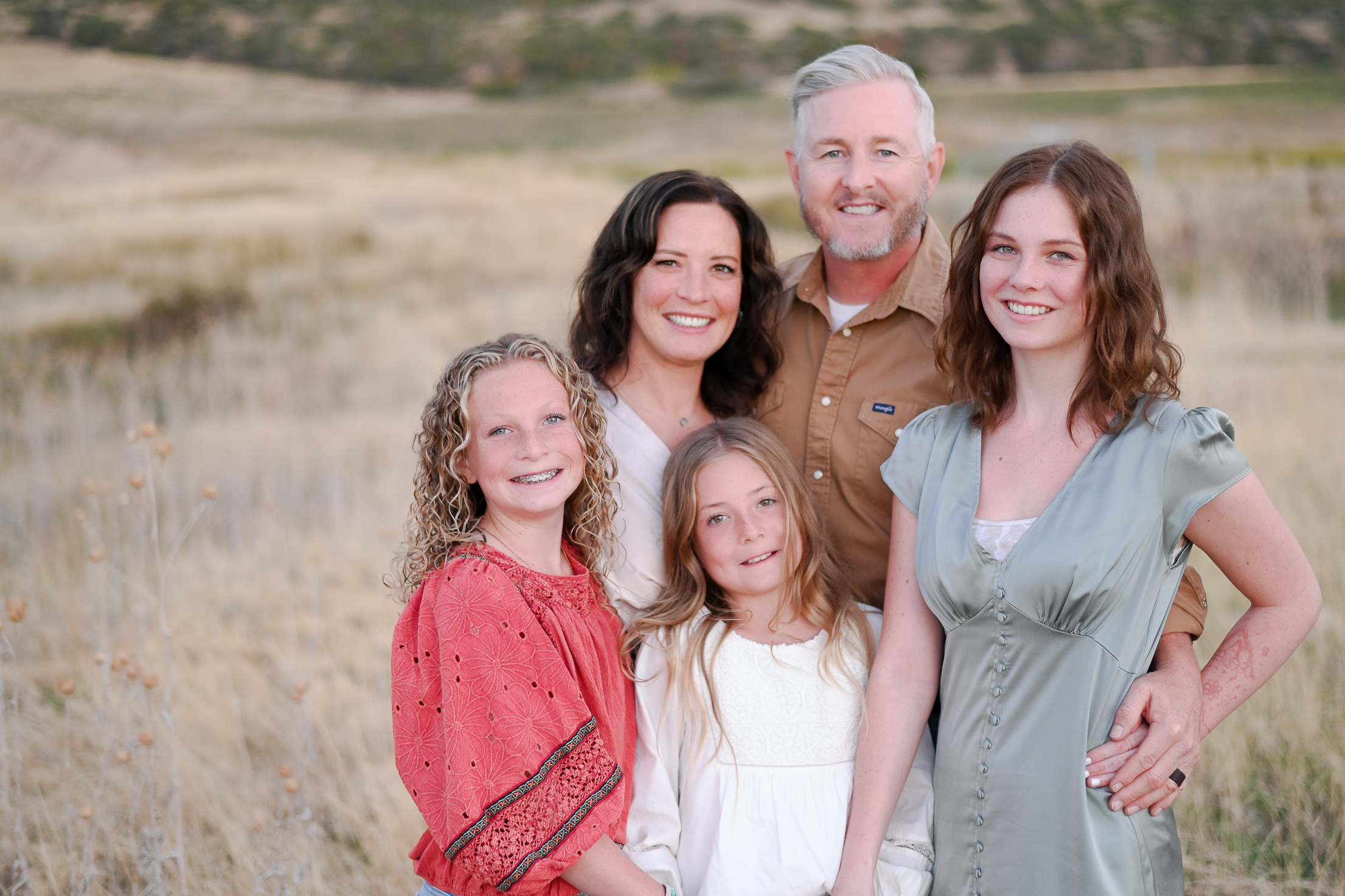 Family smiles on in the foothills of the mountains in Mapleton Utah.