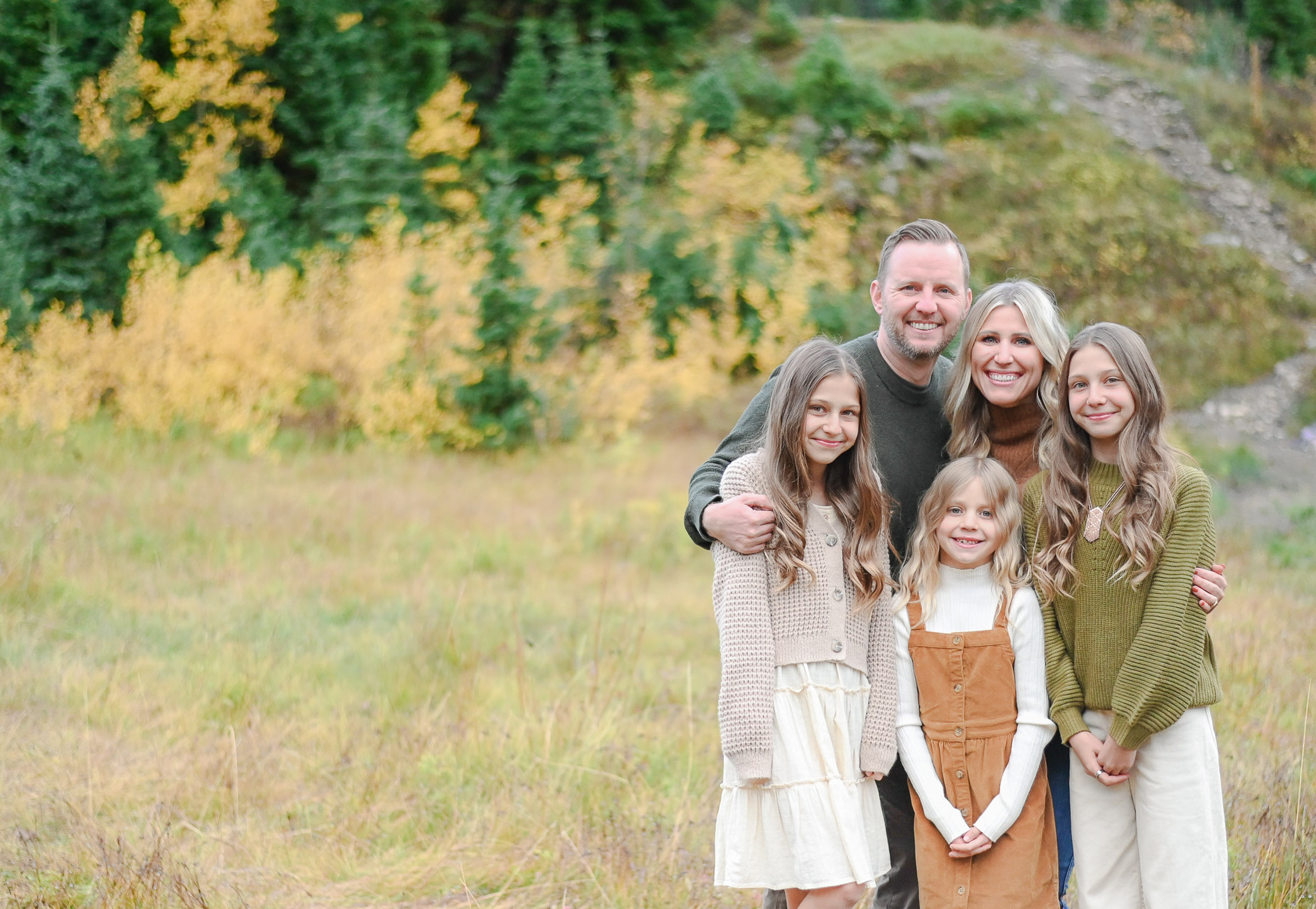 Family smiling and having fun in the crisp fall evening in Cottonwood Canyon, Utah. Fall family photos in Cottonwood Canyon