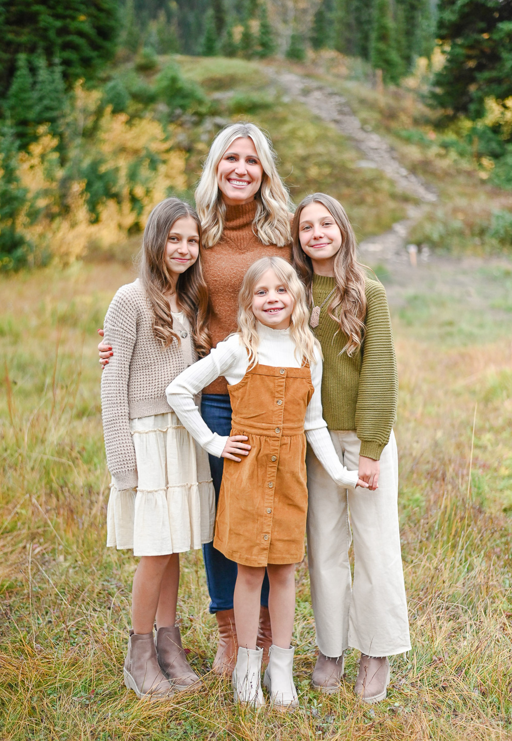 Mom smiling with her beautiful girls in the fall foliage of Big Cottonwood Canyon in Utah. Fall family photos in Cottonwood Canyon