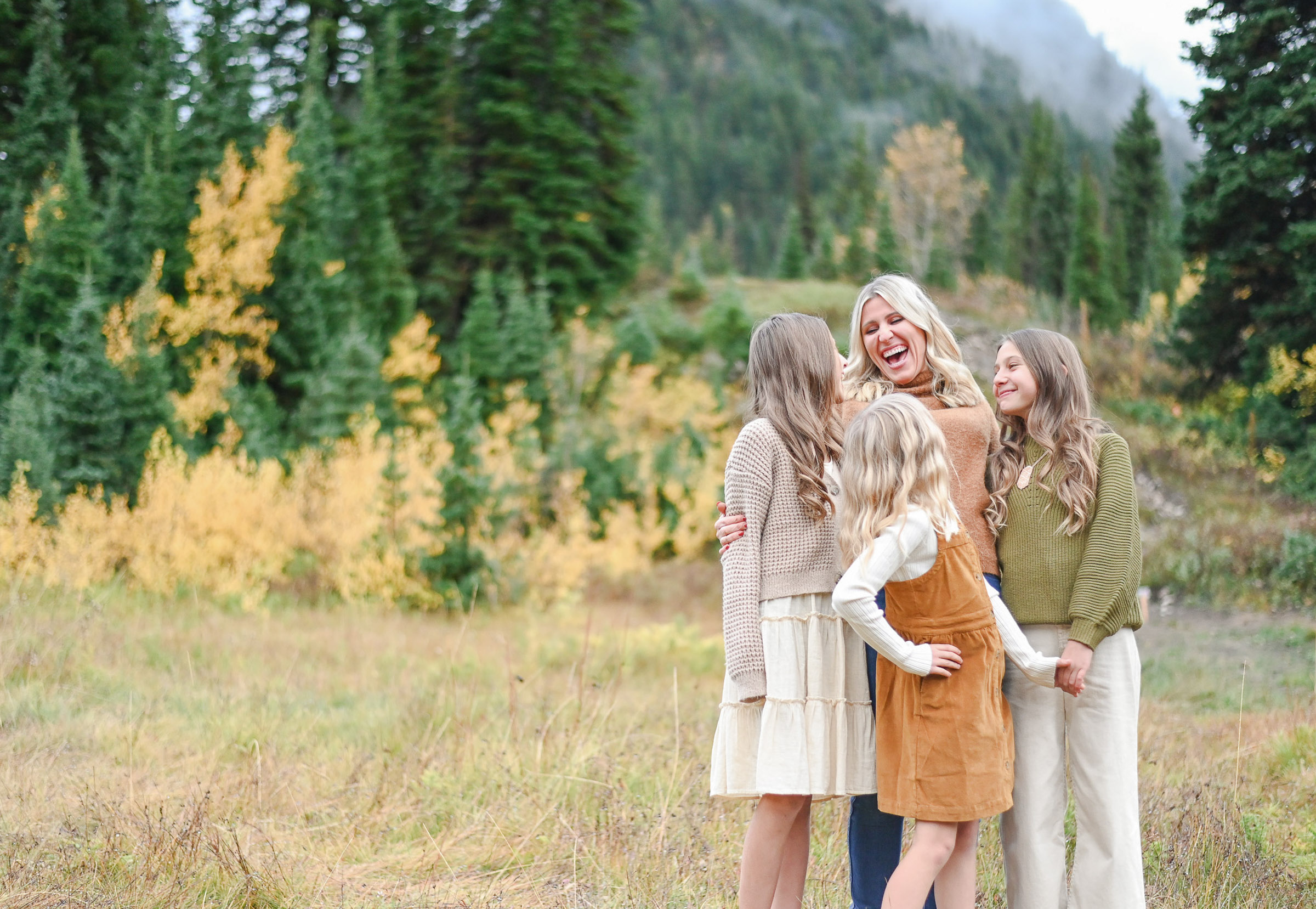 Mom laughing with her beautiful girls in the fall foliage of Big Cottonwood Canyon in Utah. Fall family photos in Cottonwood Canyon