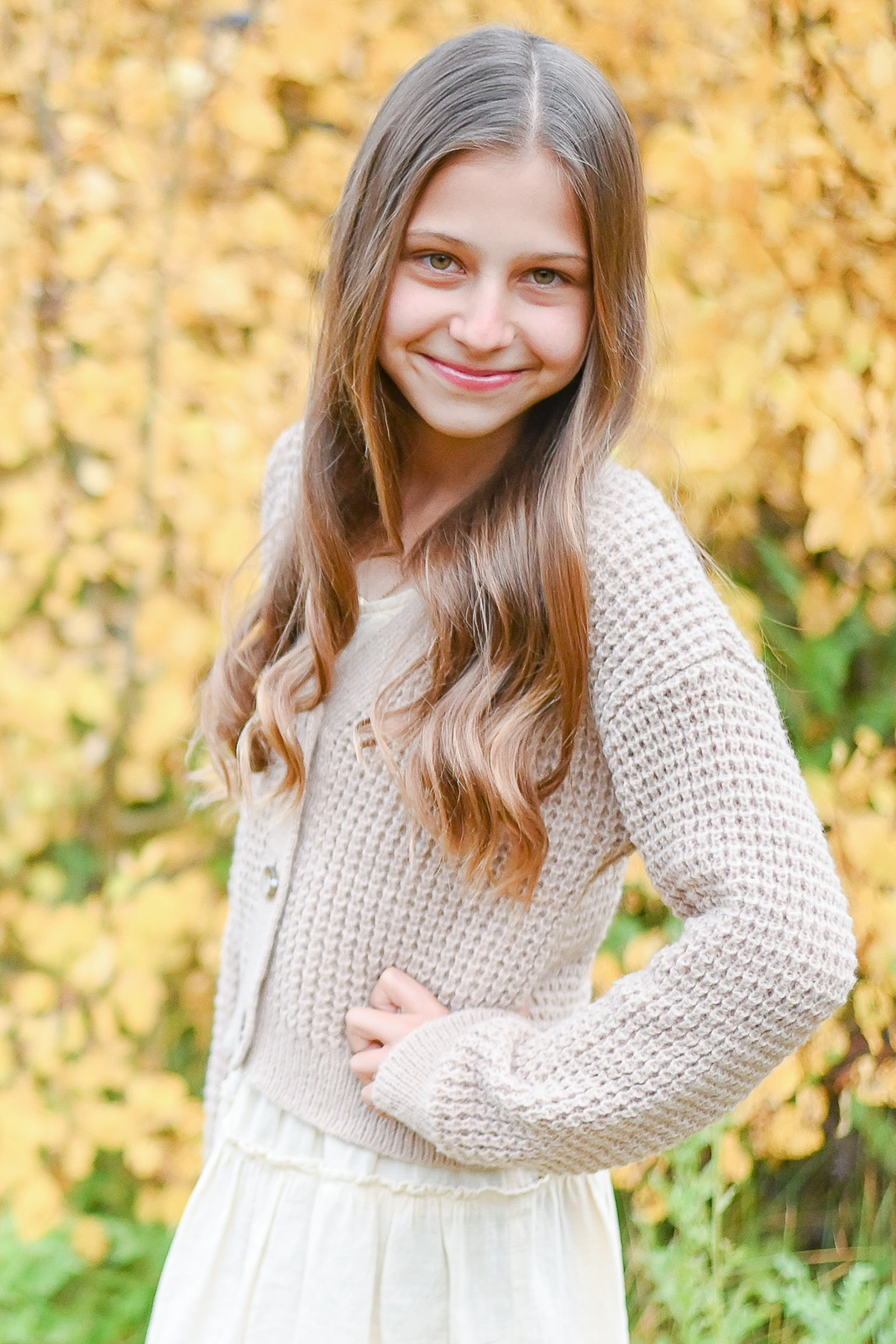 Darling girl poses her best pose as she takes her moment to shine in the fall leaves of Cottonwod Canyon Utah. Fall family photos in Cottonwood Canyon.