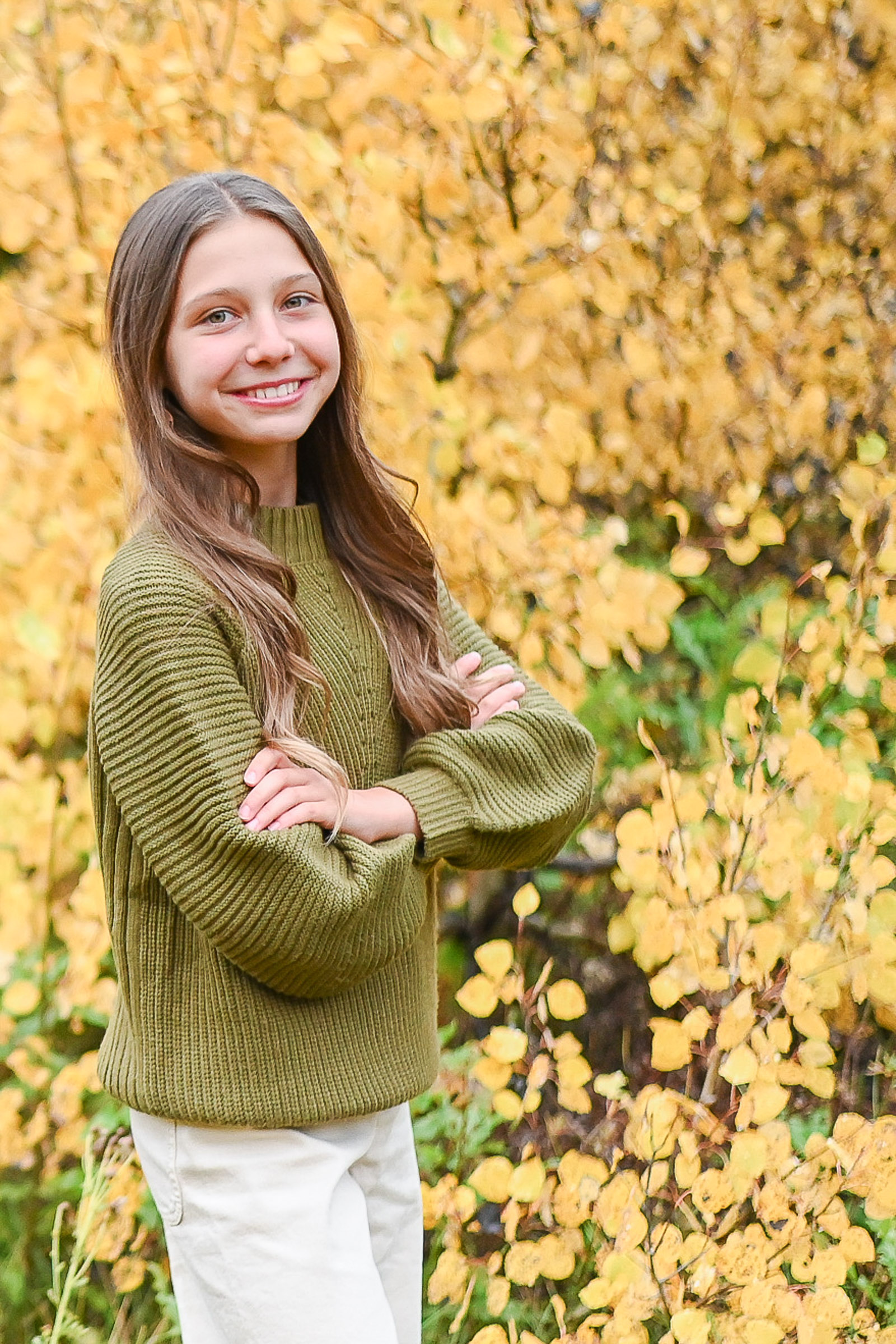 Darling girl poses her best pose as she takes her moment to shine in the fall leaves of Cottonwod Canyon Utah. Fall family photos in Cottonwood Canyon.