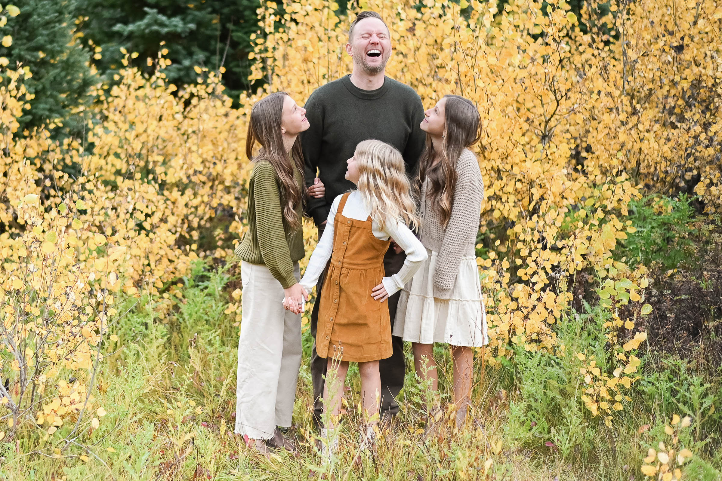 Step Dad laughing with his beautiful step daughters in the fall foliage of Big Cottonwood Canyon in Utah. Fall family photos in Cottonwood Canyon