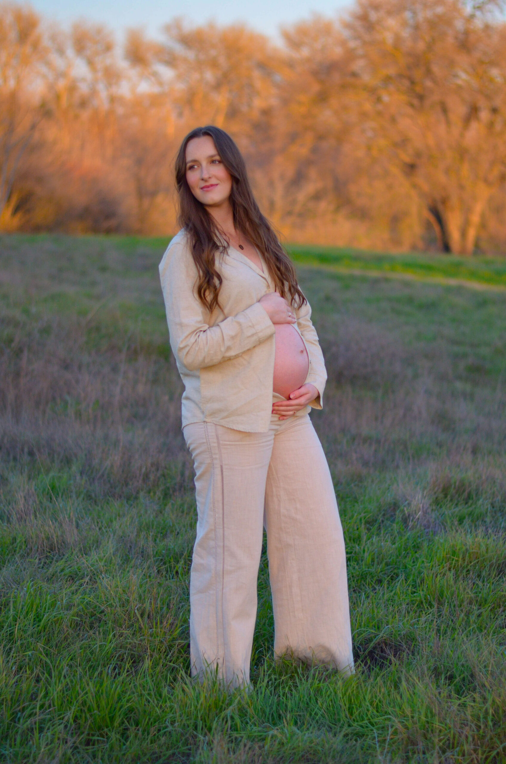 Mother to be in an open field at golden hour for her maternity shoot at Army Corps Park in Ripon, CA.