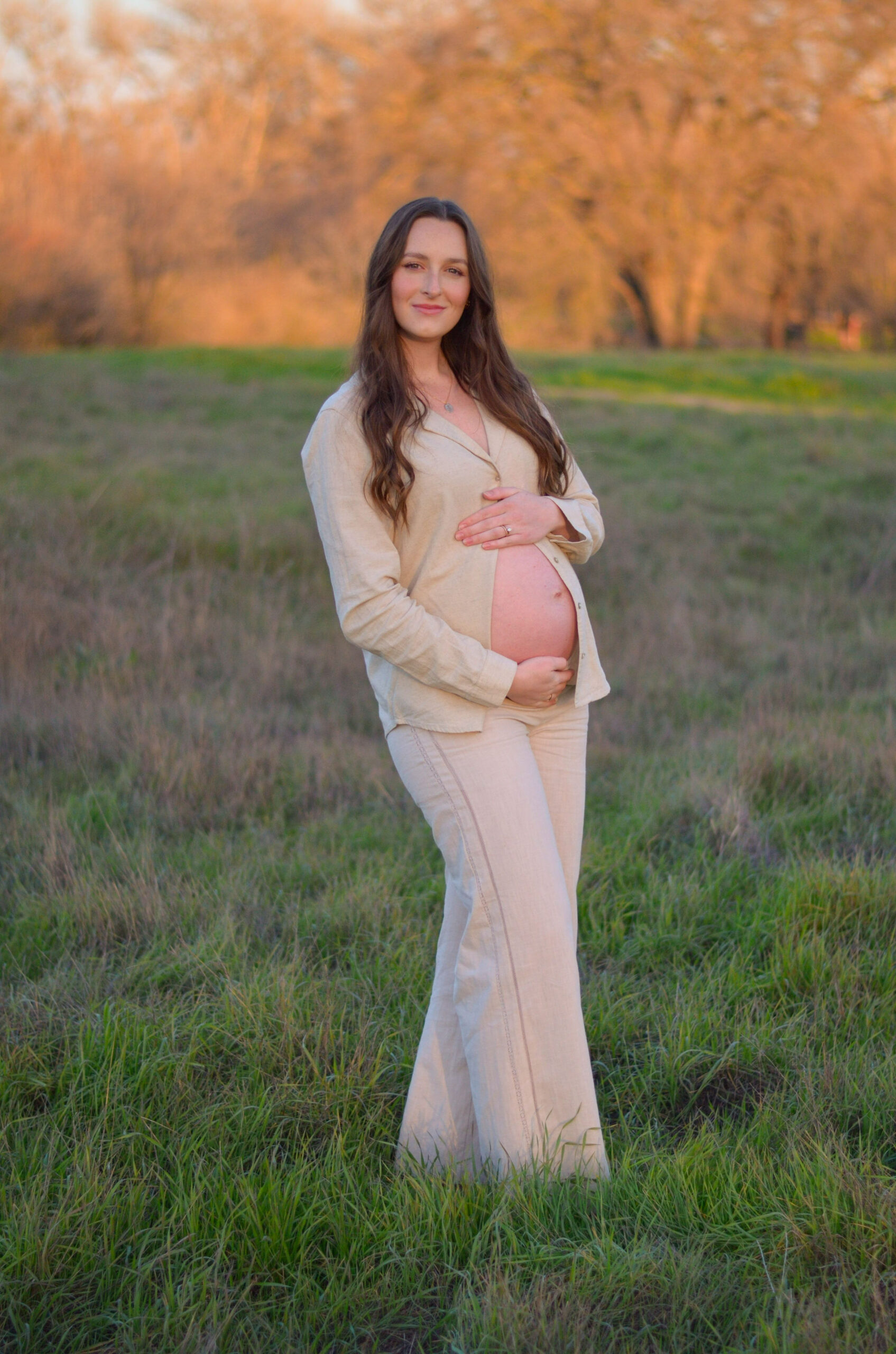 Mother to be in an open field at golden hour for her maternity shoot at Army Corps Park in Ripon, CA.