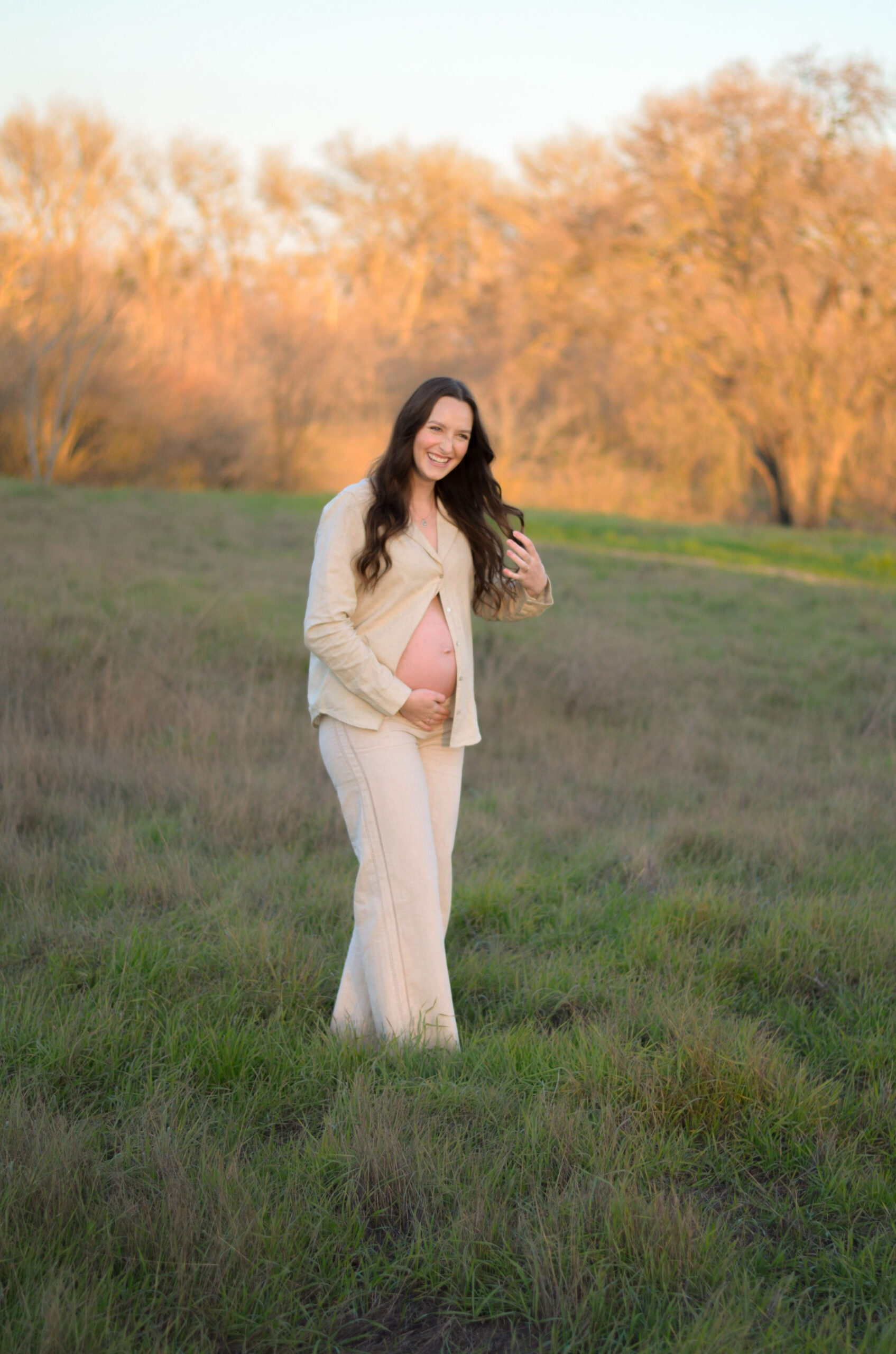 Mother to be in an open field at golden hour for her maternity shoot at Army Corps Park in Ripon, CA.