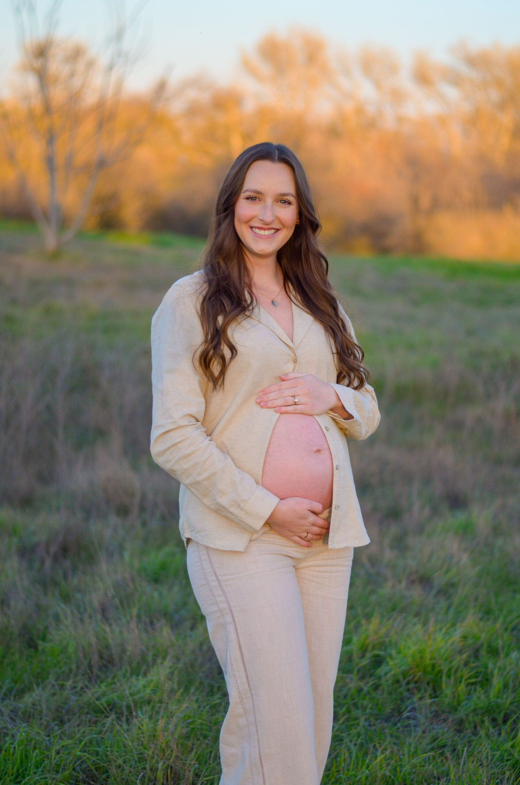 Mother to be in an open field at golden hour for her maternity shoot at Army Corps Park in Ripon, CA.