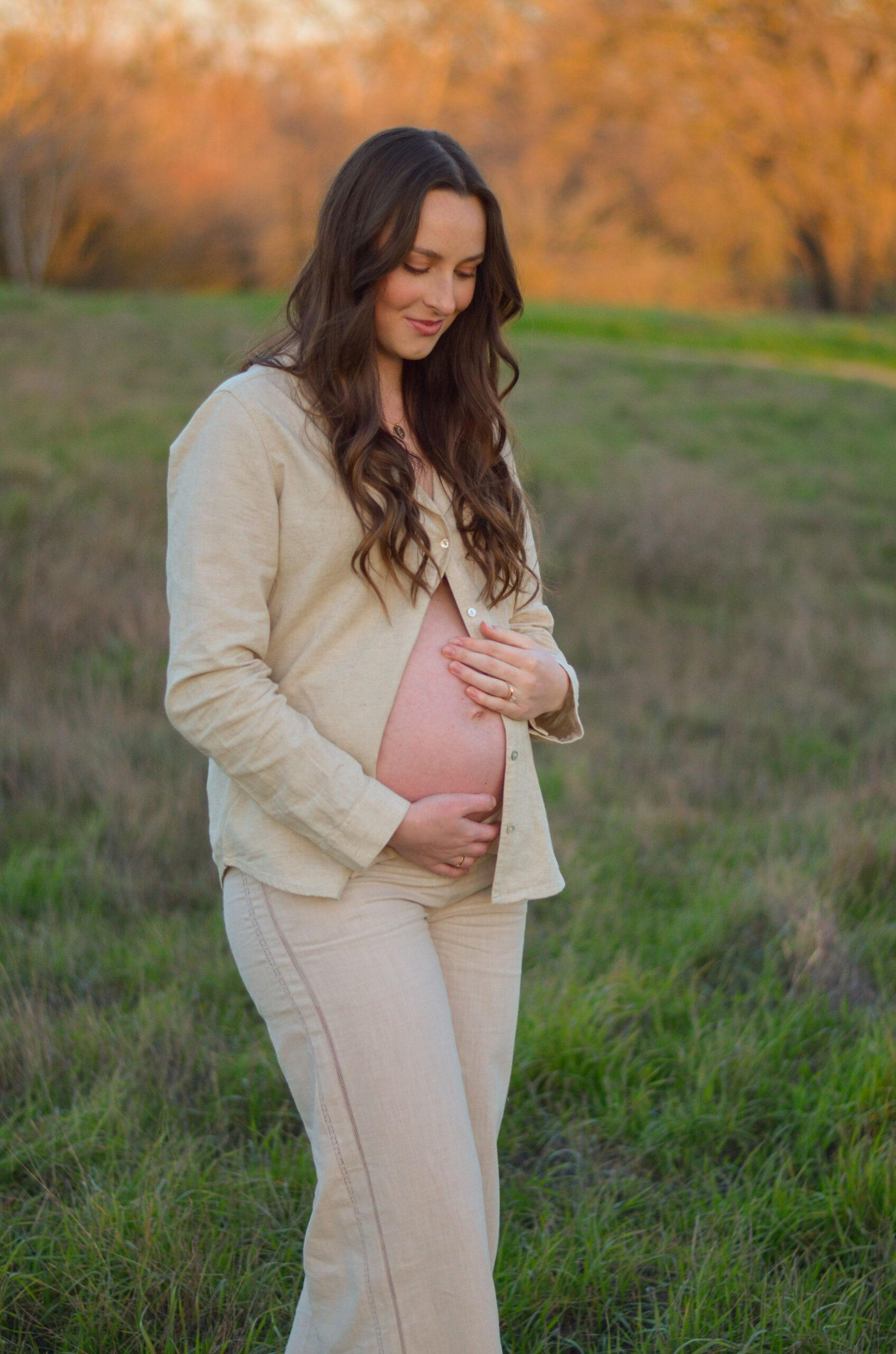 Mother to be in an open field at golden hour for her maternity shoot at Army Corps Park in Ripon, CA.