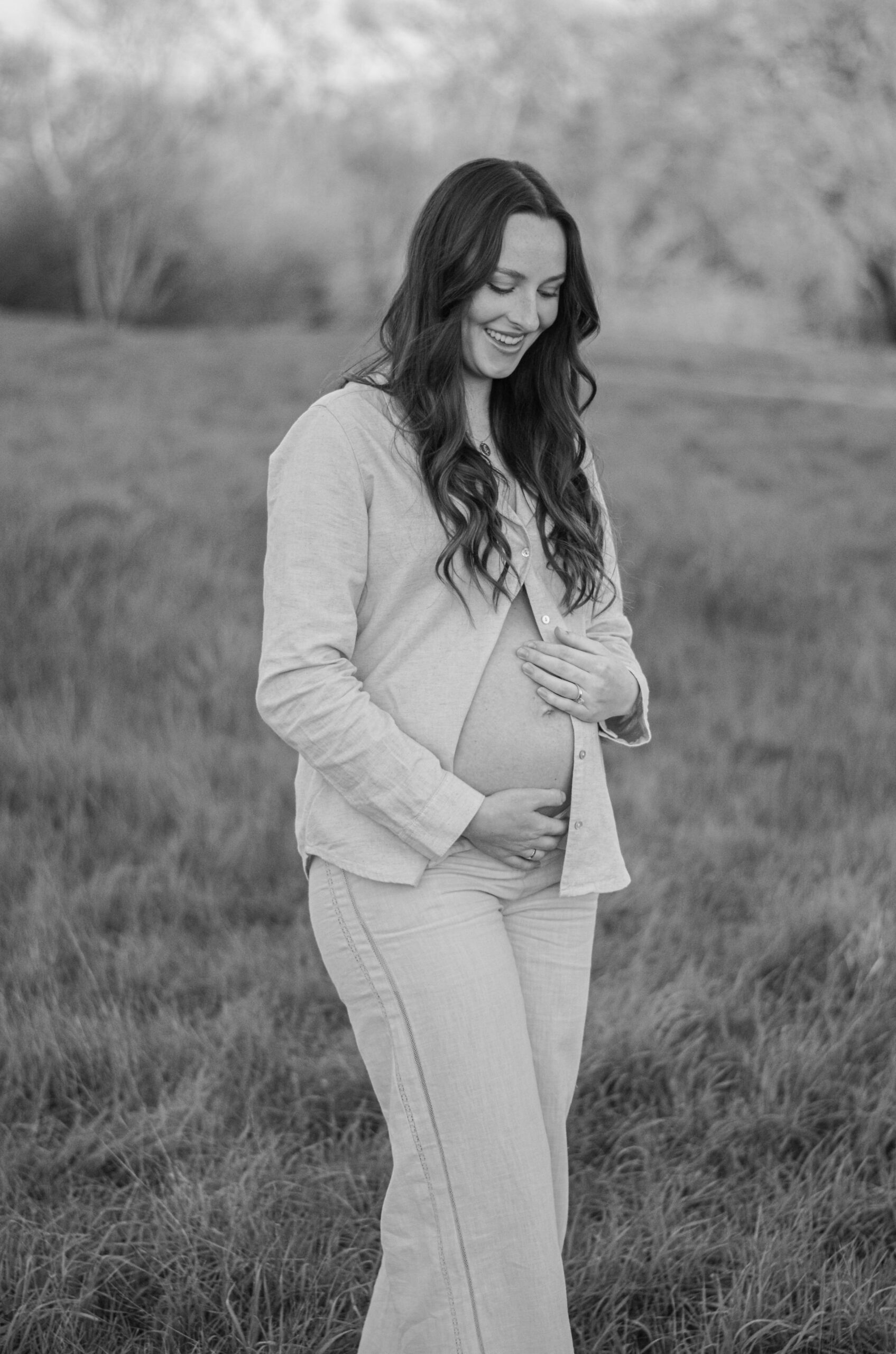 Mother to be in an open field at golden hour for her maternity shoot at Army Corps Park in Ripon, CA.