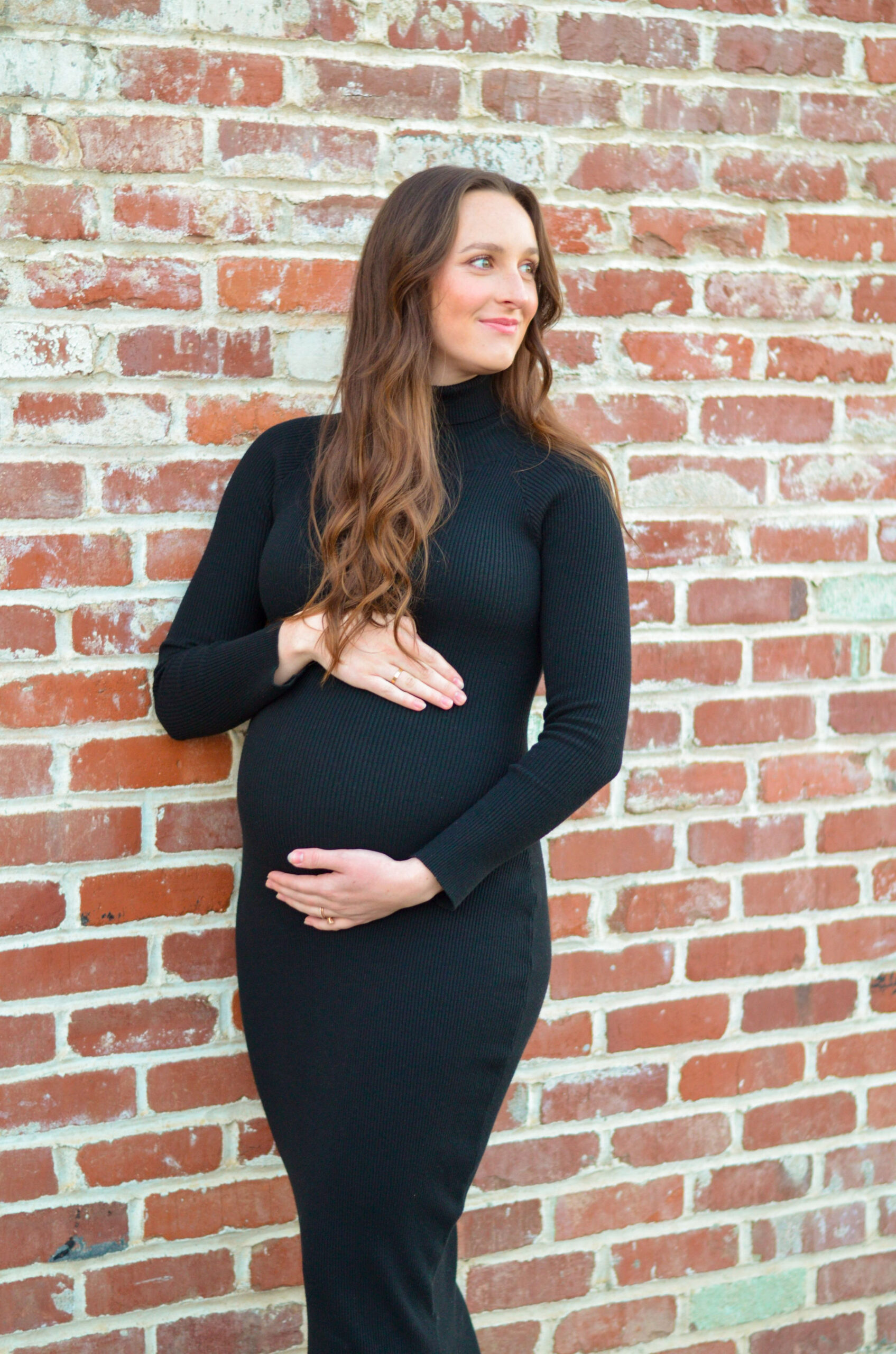 Mother to be against a brick wall during golden hour for her maternity shoot in Ripon, CA.