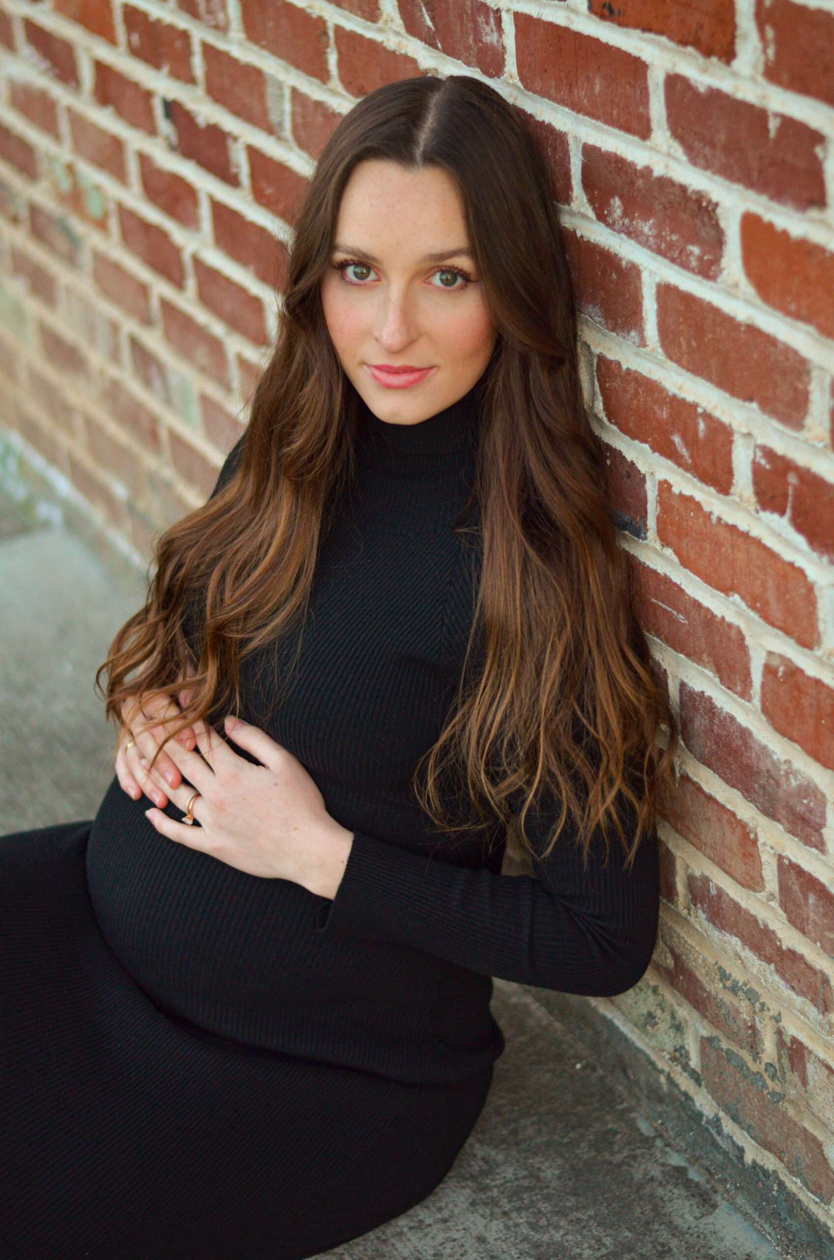 Mother to be against a brick wall during golden hour for her maternity shoot in Ripon, CA.