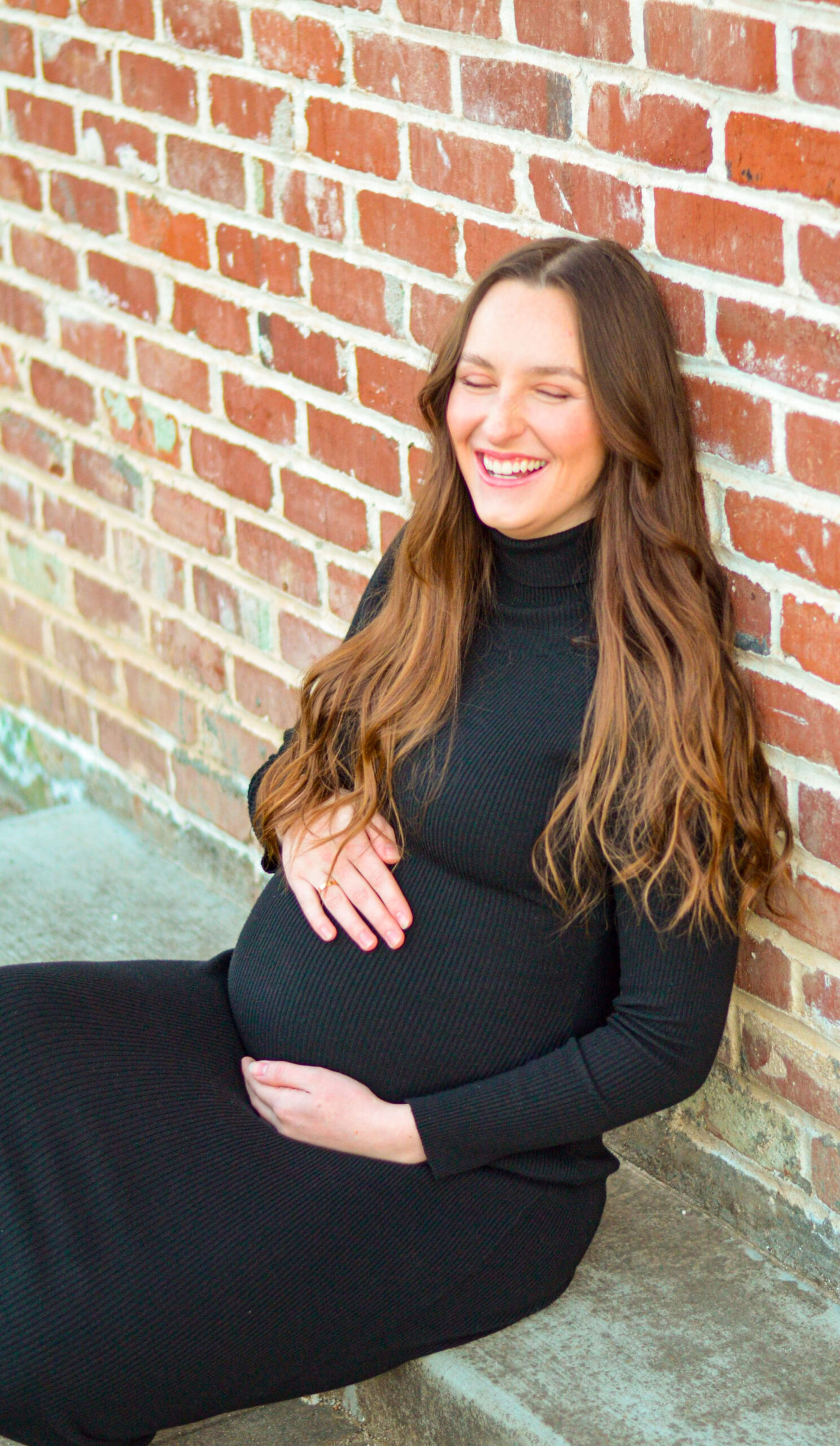 Mother to be against a brick wall during golden hour for her maternity shoot in Ripon, CA.