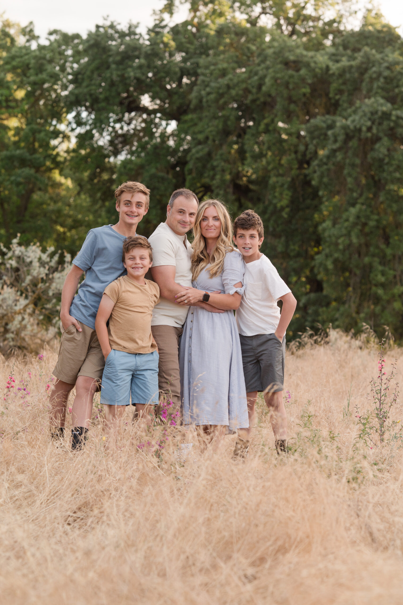 A family of five posing for the camera as they smile at Oak Grove Park in Ripon California