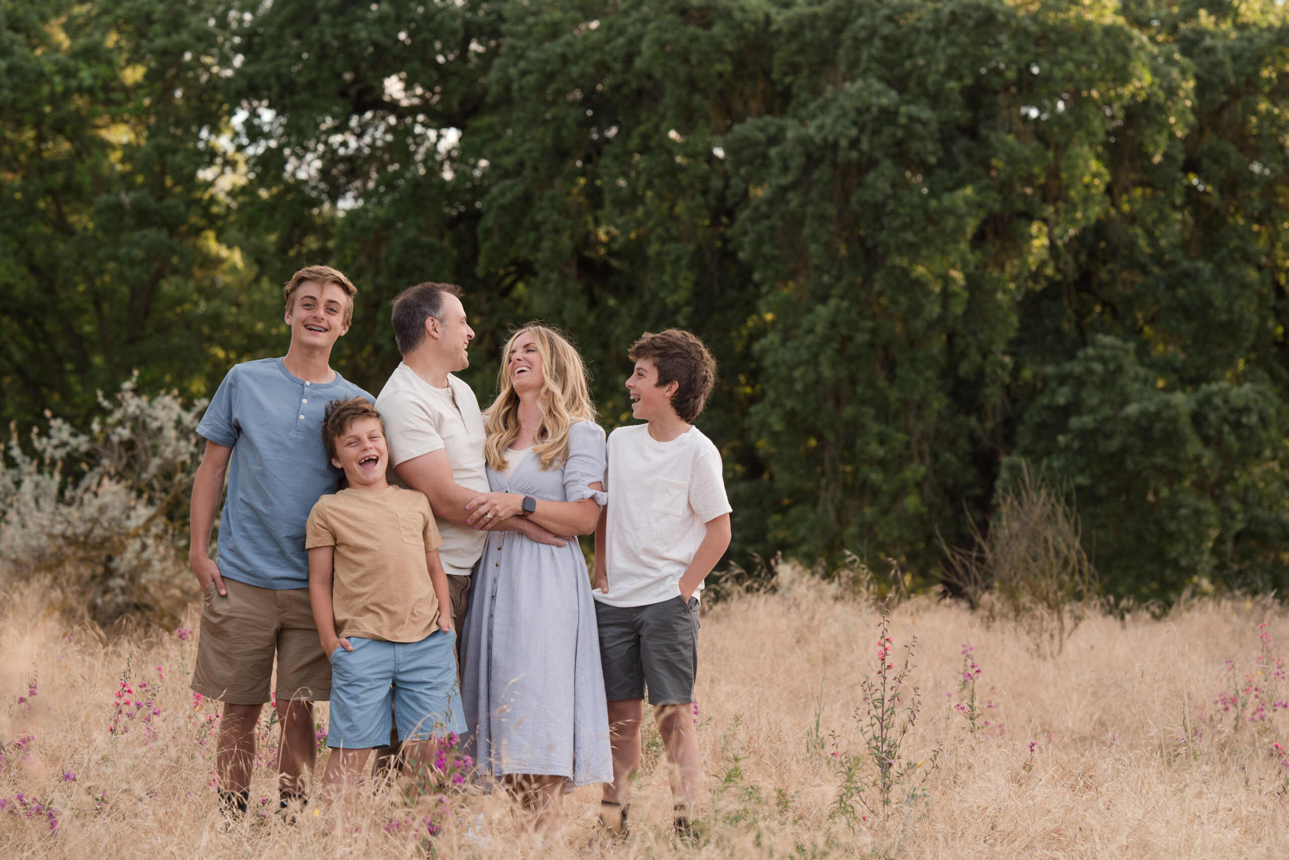 Family laughing in between poses during their sunset session at Oak Grove Park in Ripon, California.