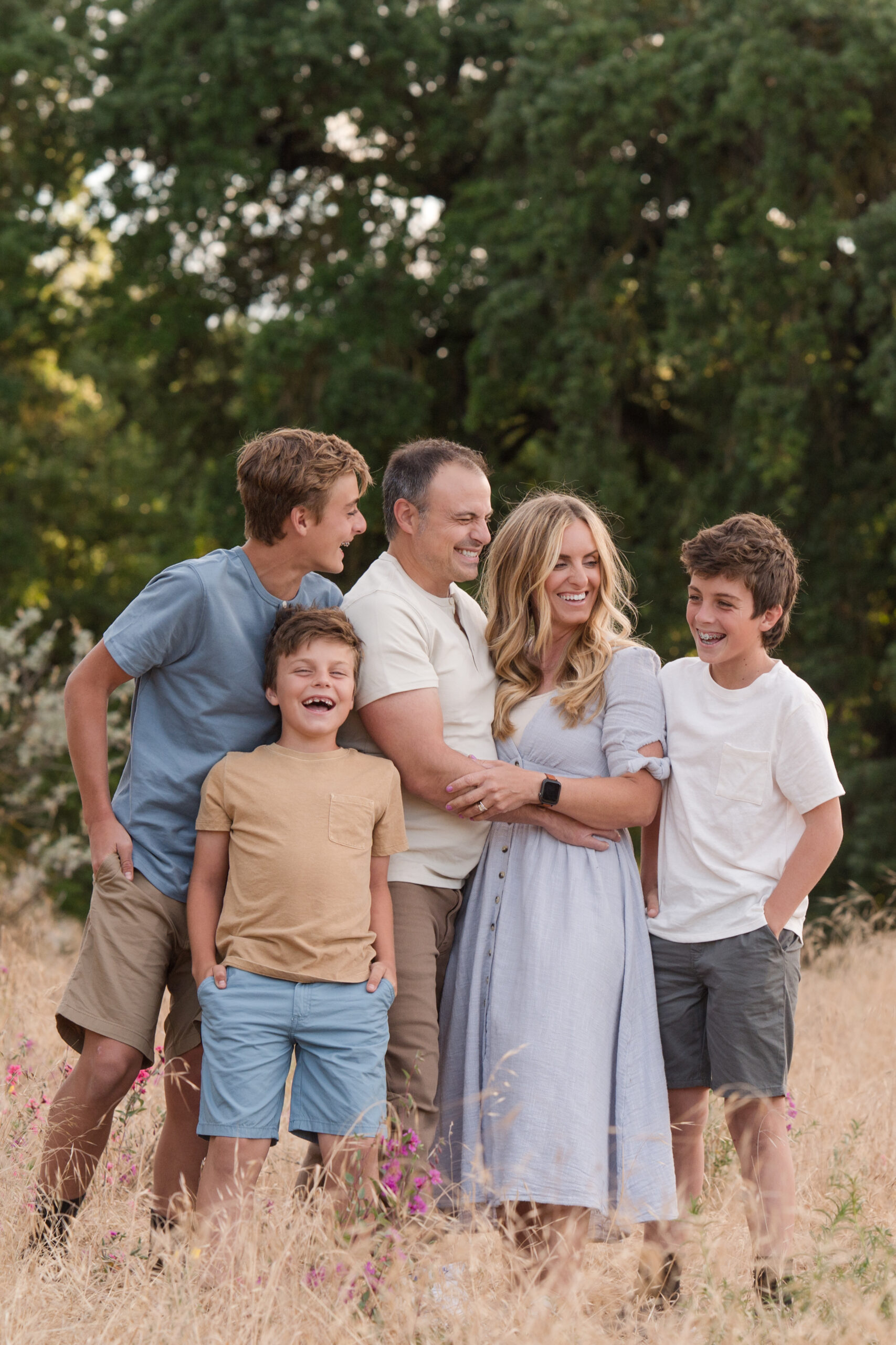 Family laughing in between poses during their sunset session at Oak Grove Park in Ripon, California.