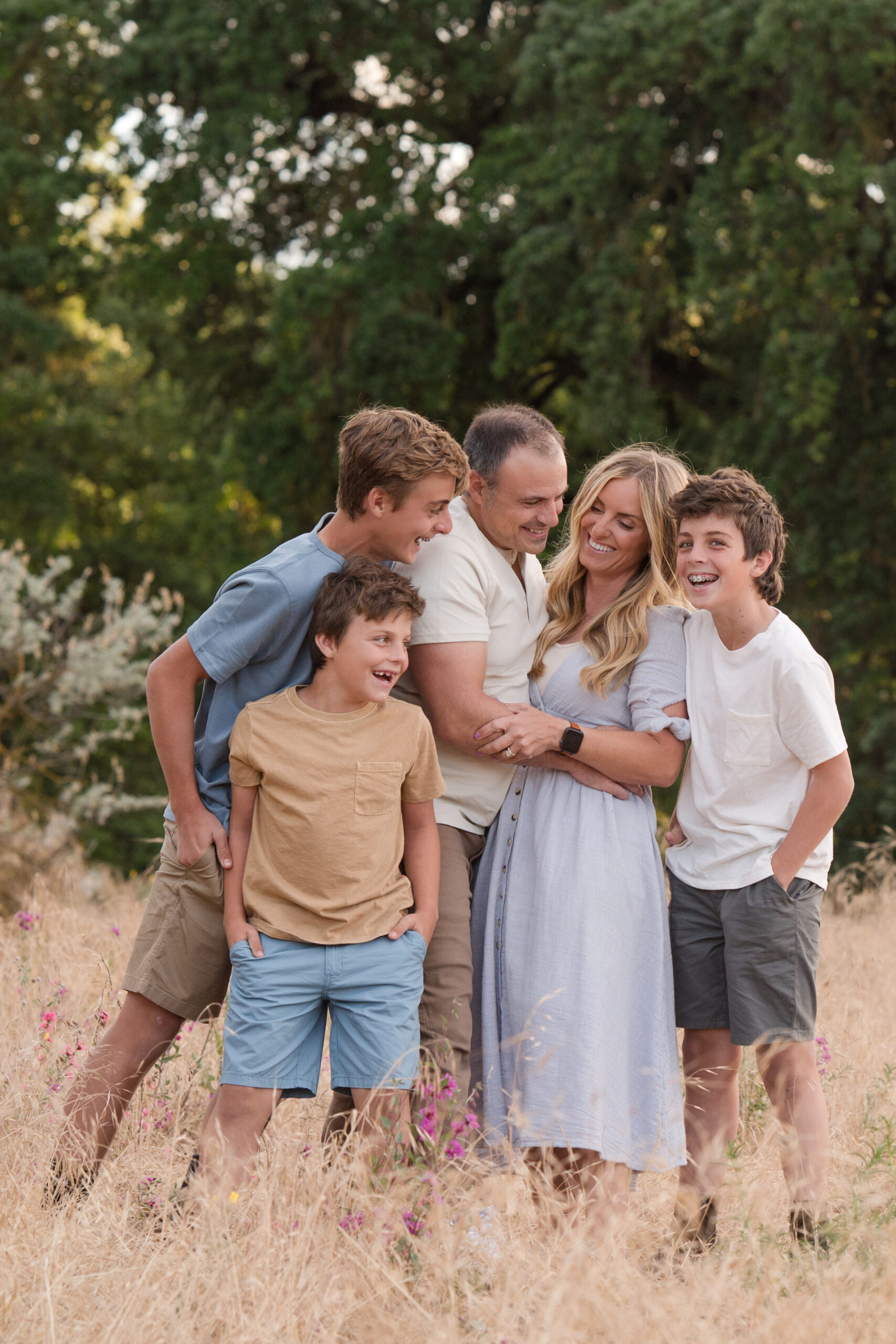 Family laughing in between poses during their sunset session at Oak Grove Park in Ripon, California.