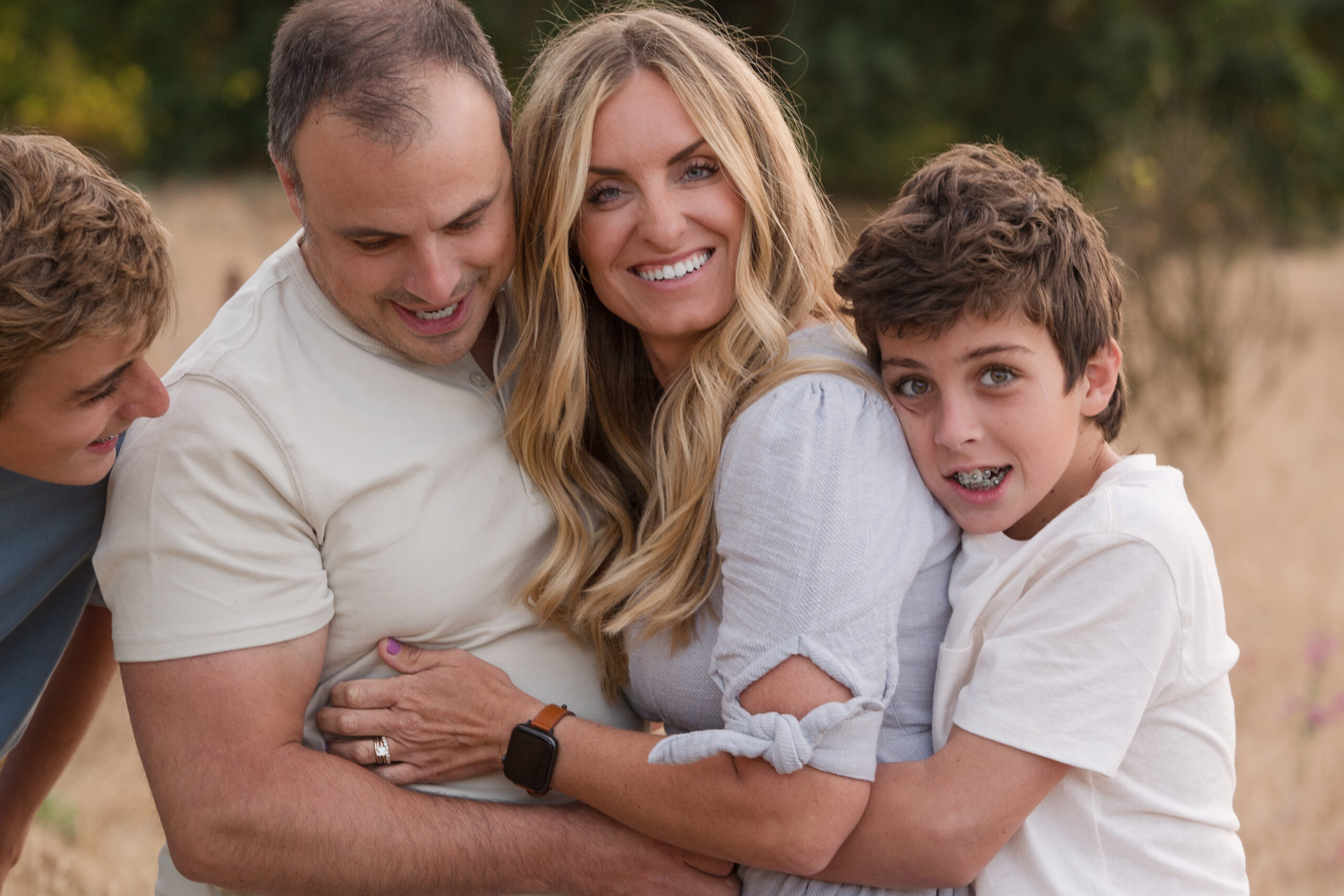 A son grabbing a quick hug on his Mom before setting up for the next pose, while his brother looks on. Oak Grove, Ripon, California