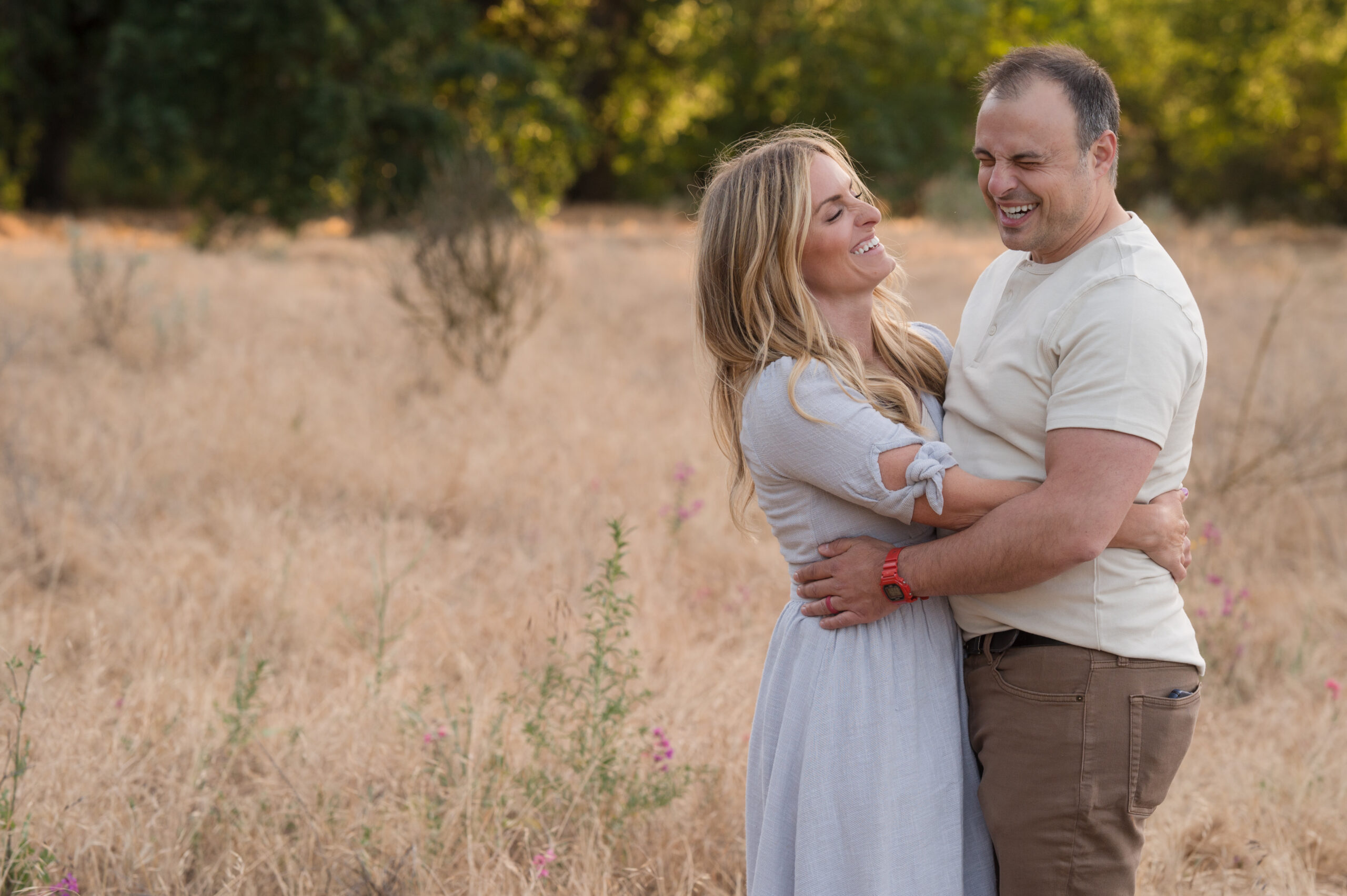 Mom and Dad embrace in laughter in a candid moment in Oak Grove Park, Ripon, California.