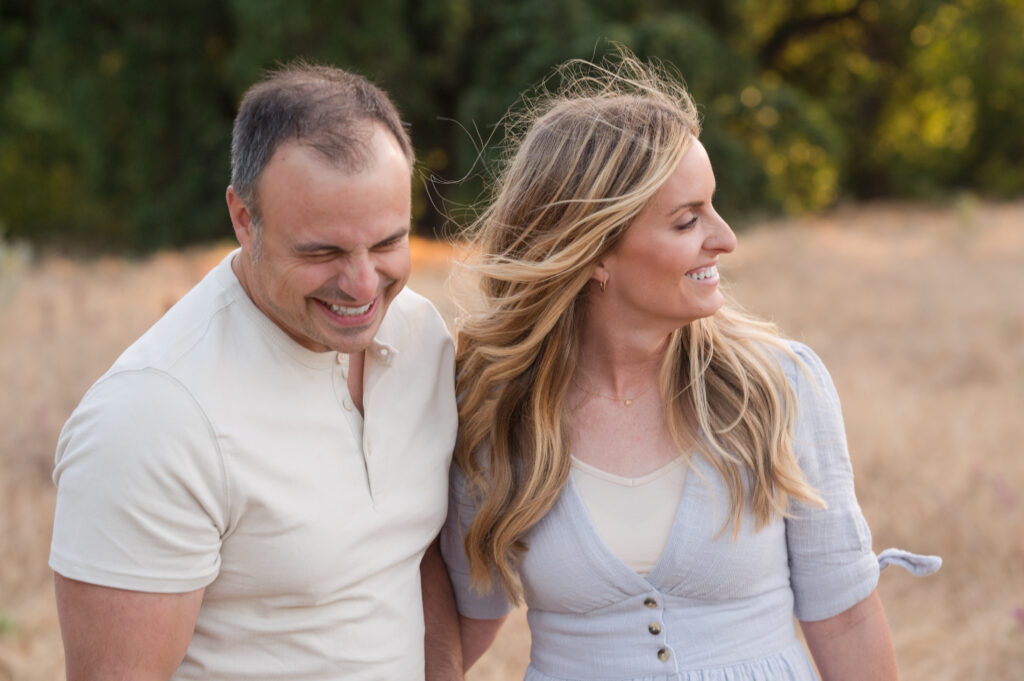 Husband and wife caught in laughter in a candid moment in Oak Grove Park, Ripon, California.