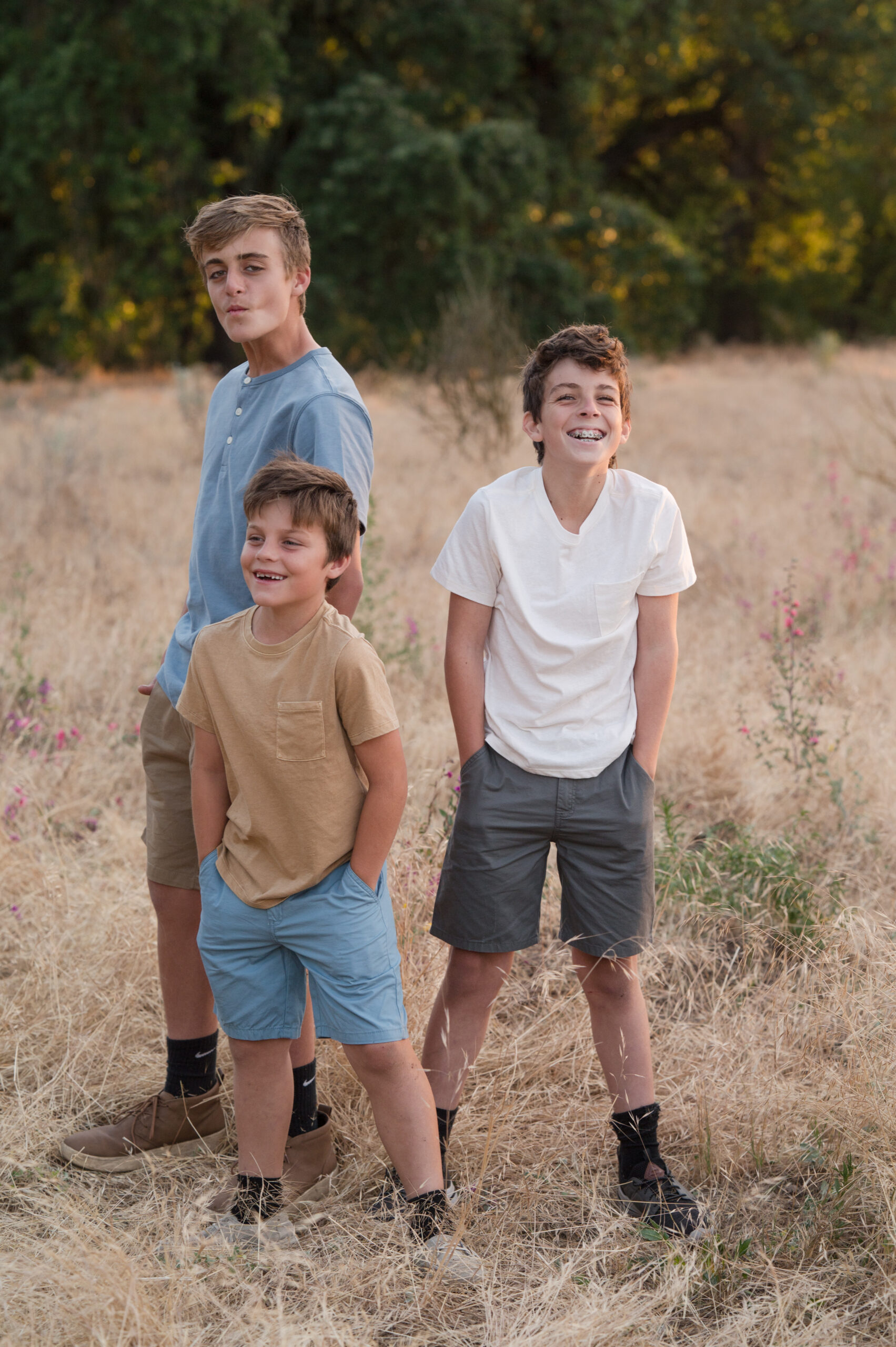 Three boys do their best not to smile as they do their best model faces at Oak Grove Park in Ripon California.