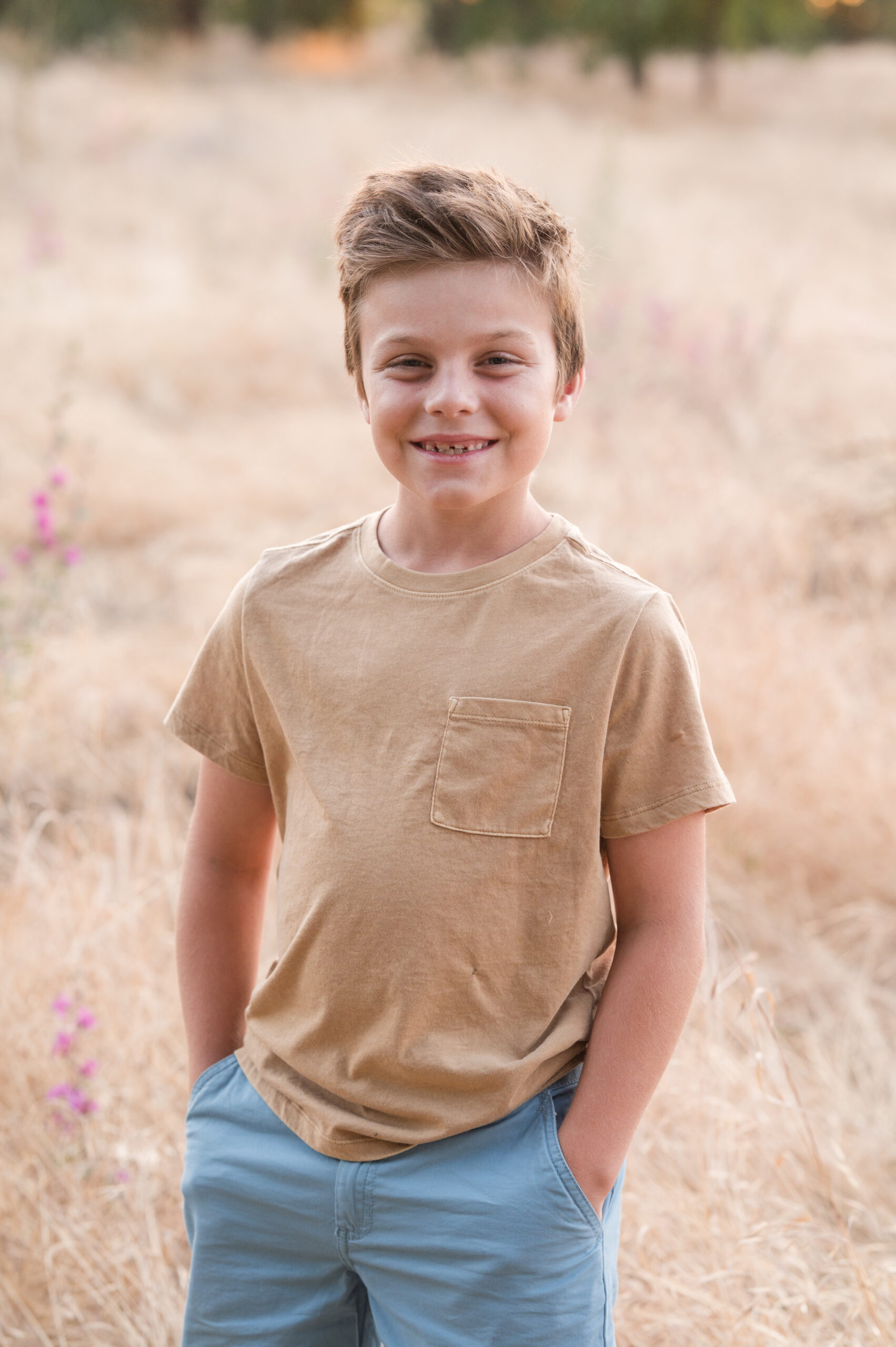 A boy smiling at the camera as he puts on his best posture and pose for his shining moment at Oak Grove Park in Ripon California.