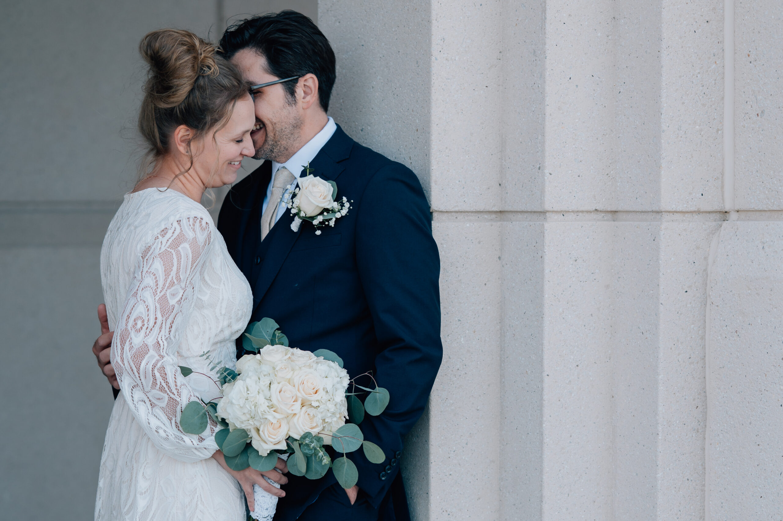 Groom whispering a sweet thought into his bride's ear as she smiles with her eyes closed and enjoying the moment. Saratoga Springs Utah