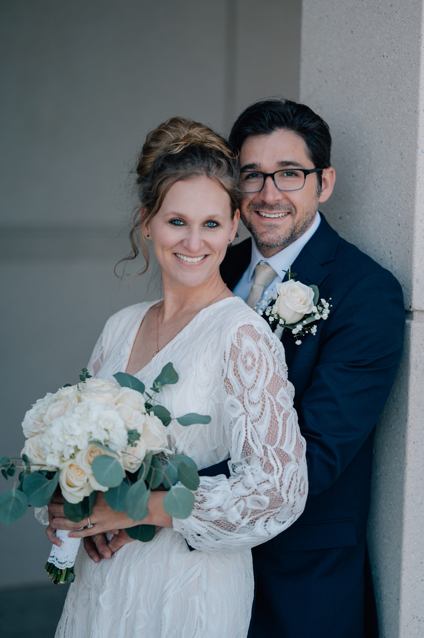 Bride and groom smile on. The bride's eyes are a piercing blue as they bring their genuine smiles to the camera at the LDS Temple in Saratoga Springs, UT.