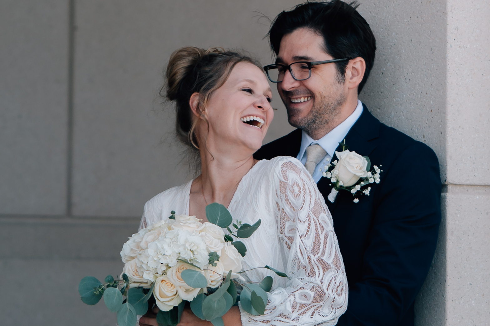 Bride and groom laughing in a framed doorway at the Saratoga Springs LDS Temple in Utah