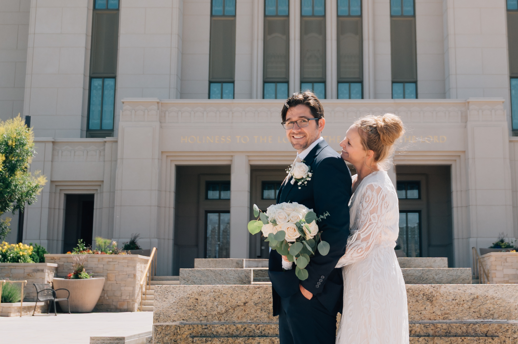 Bride smiles up at her groom in front of the LDS Temple in Saratoga Springs Ut