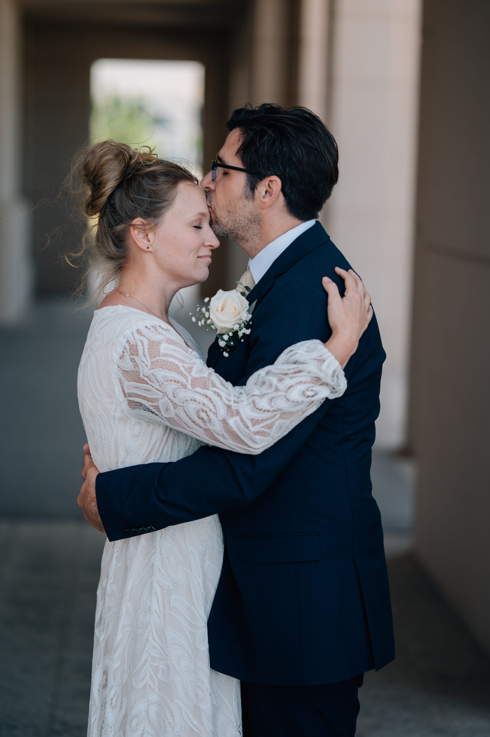 Groom kisses his wife on her forehead bringing in a magical moment with such tenderness, and love.