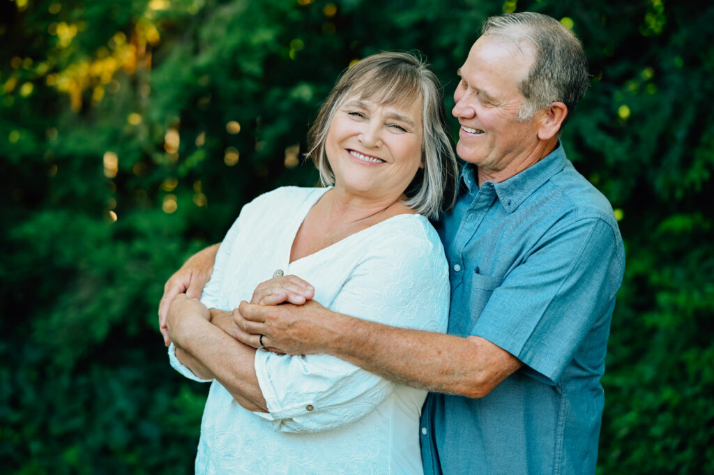 Grandpa steals a little look at Grandma smiling sweetly while they are embracing.