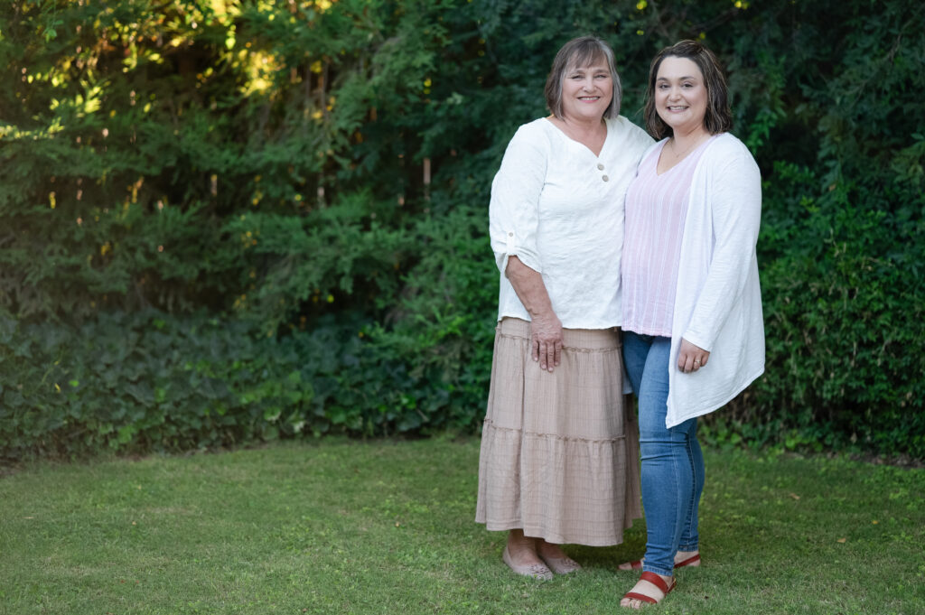 Mom with her sweet daughter embracing with arms behind each other