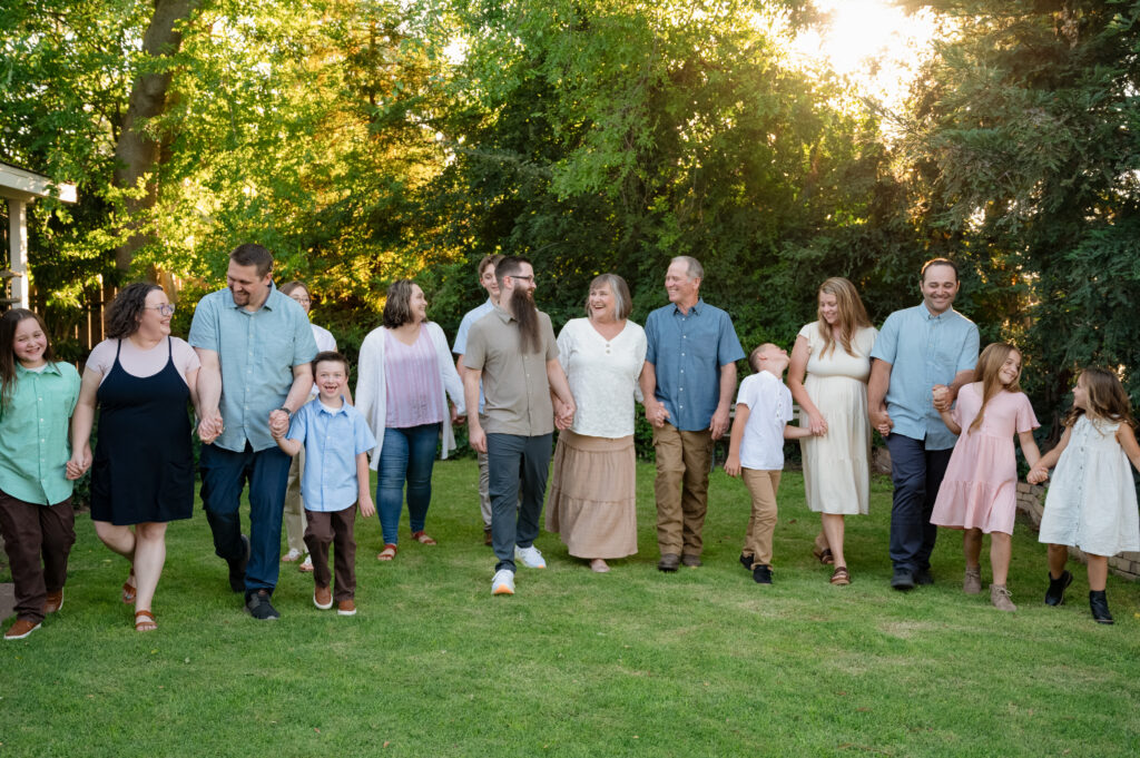 The entire family walking hand in hand through the front yard of Grandma & Grandpa's house. Everyone is laughing and looking at each other.