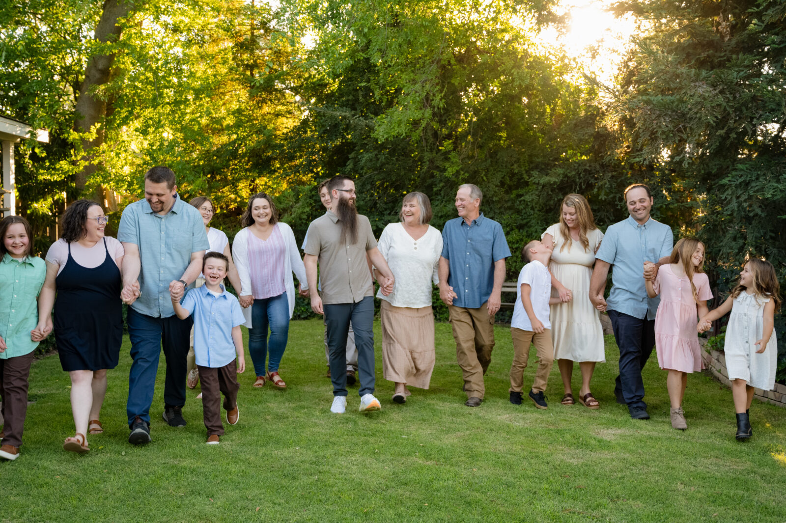 The entire family walking hand in hand through the front yard of Grandma & Grandpa's house. Everyone is laughing and looking at each other.