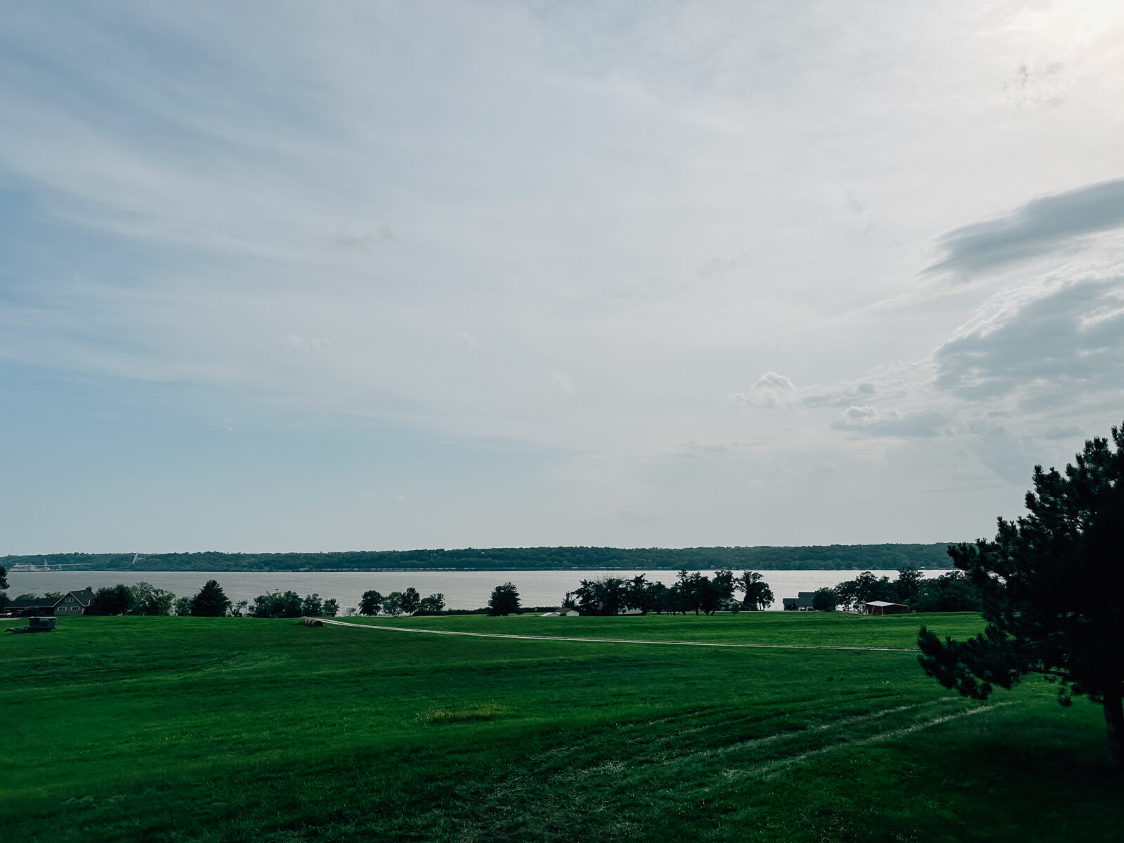 The Mississippi River outside of Nauvoo, IL. Green grasses, and tree lined river. 
