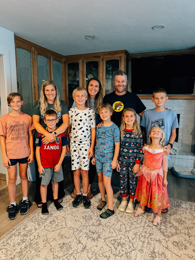 An extended family group smiles on in a home in North Orem, UT. 