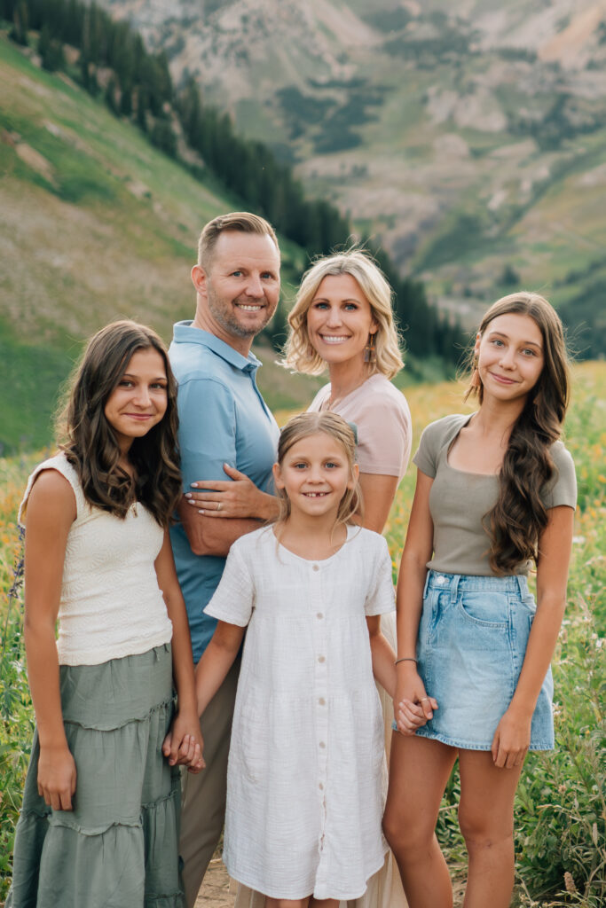 A family of five surrounded by summer wildflowers in Little Cottonwood Canyon, Utah.