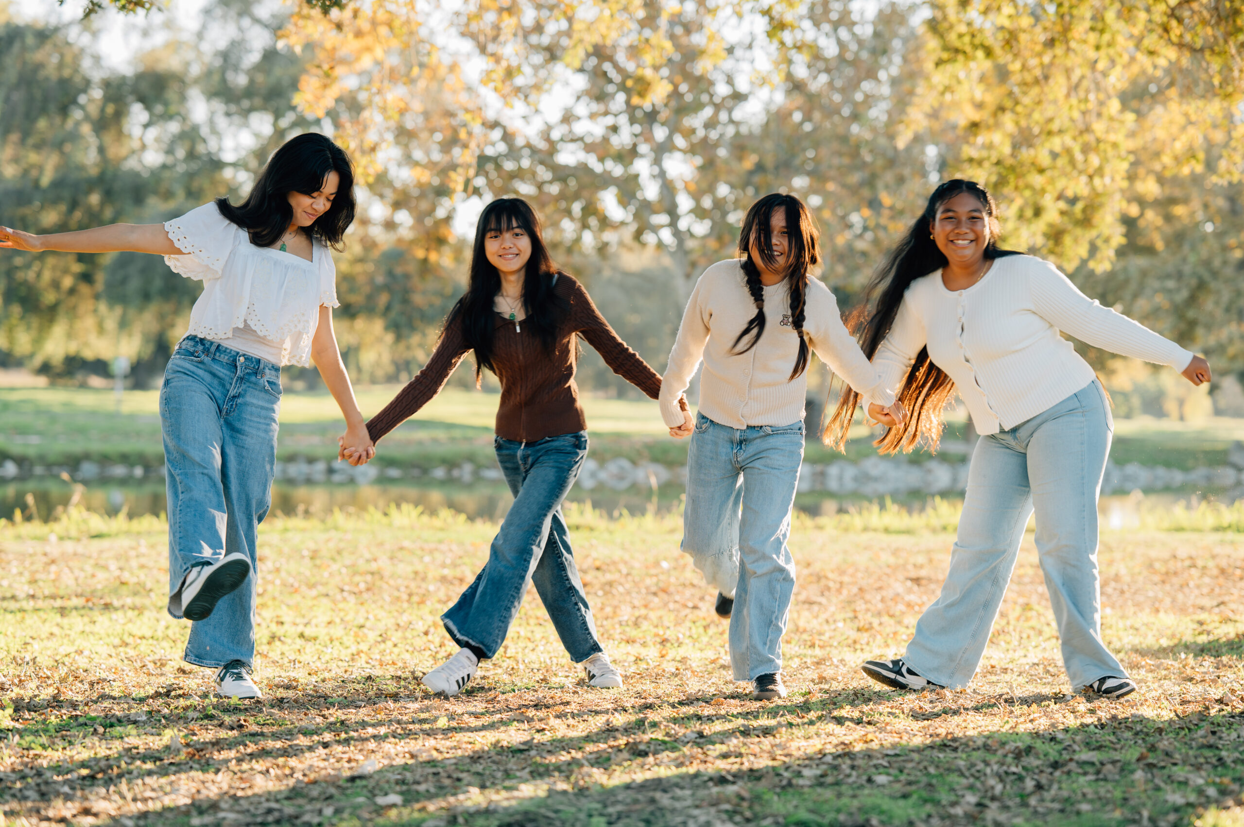 Candid moment of family members laughing together under willow trees at Oak Grove Park
