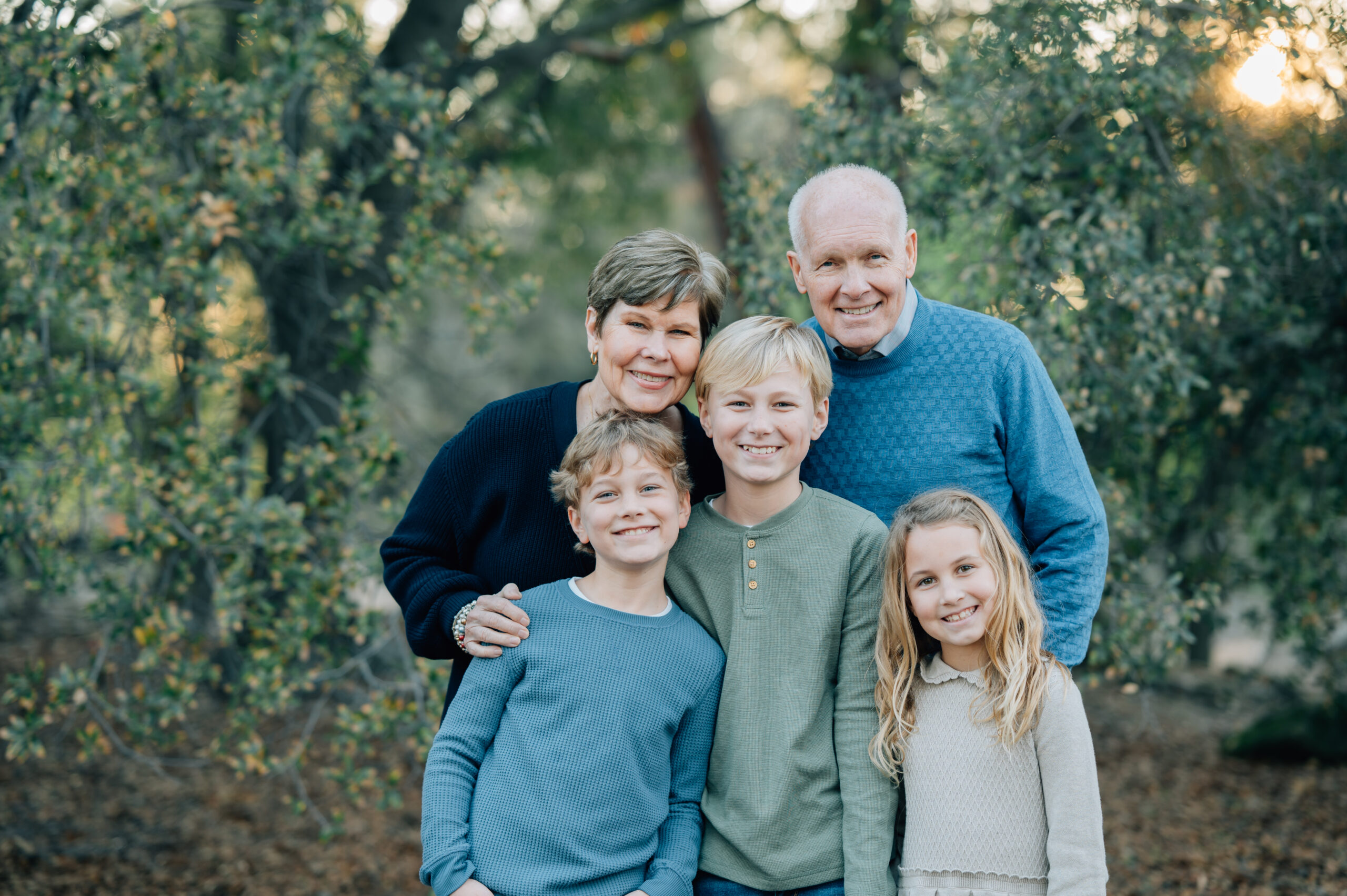 Grandparents smiling with three grandchildren during a fall family photography session
