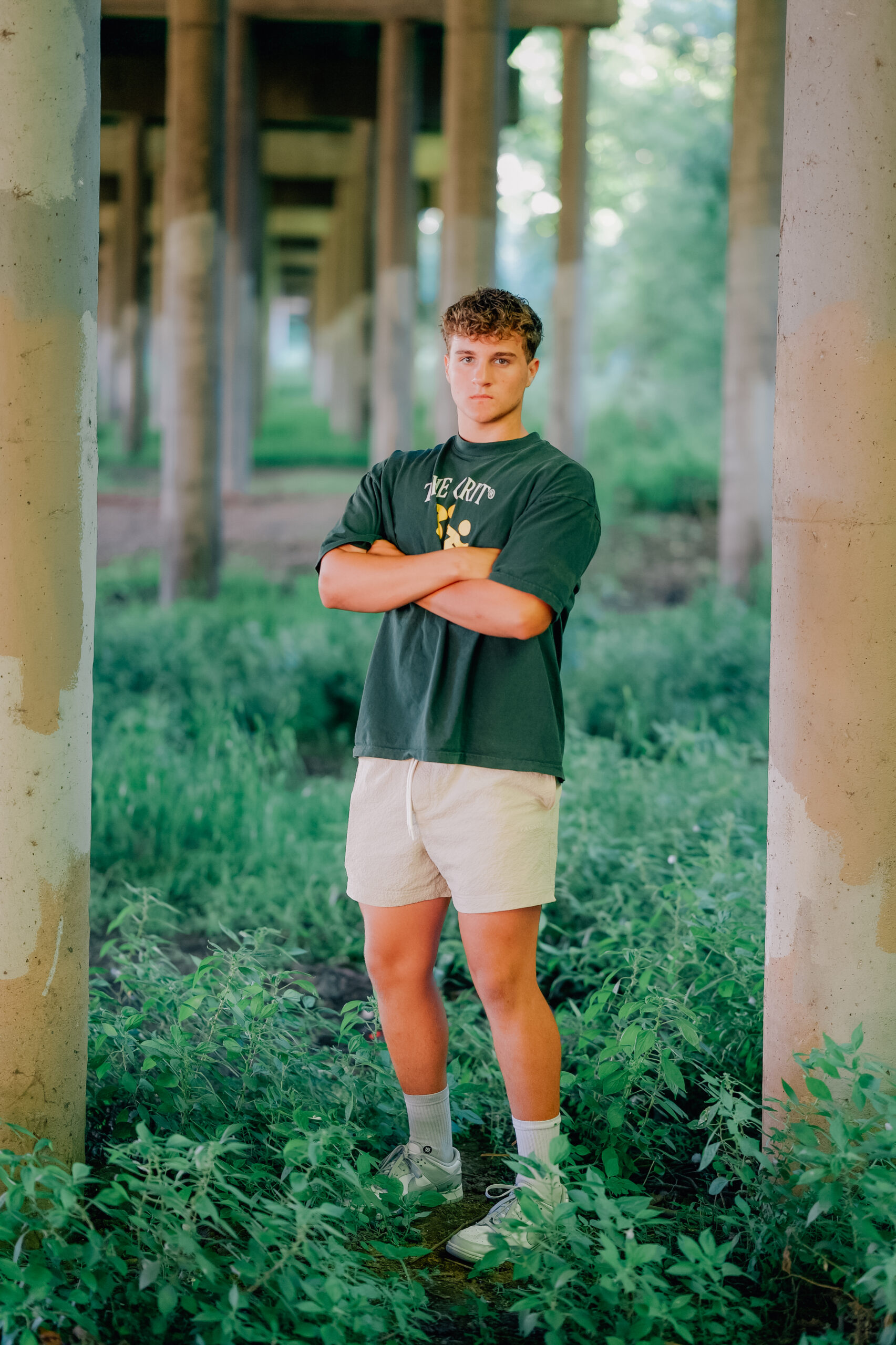 Graduate folding arms under an over pass in between concrete beams.