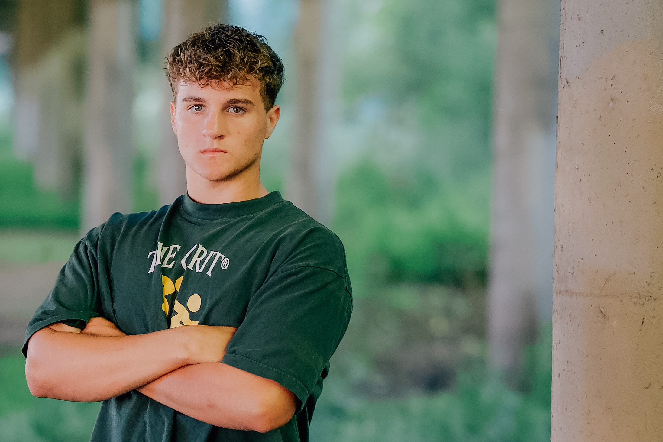 Graduate folding arms under an over pass in between concrete beams.