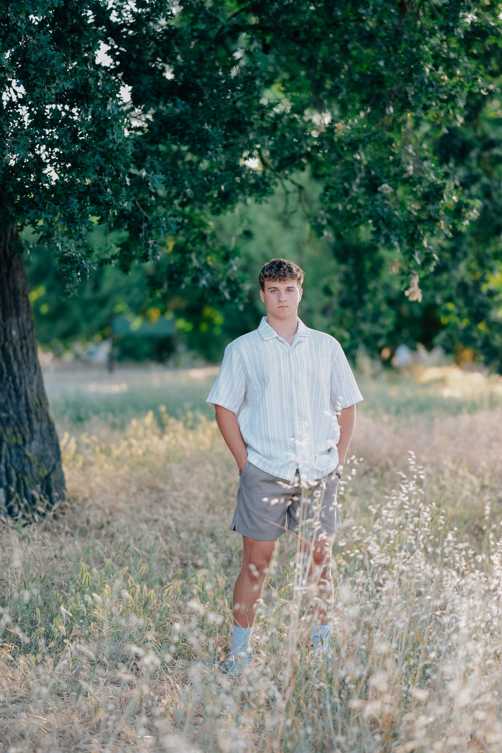 Graduate standing strong with hands in pockets while looking at the camera with a straight face. 