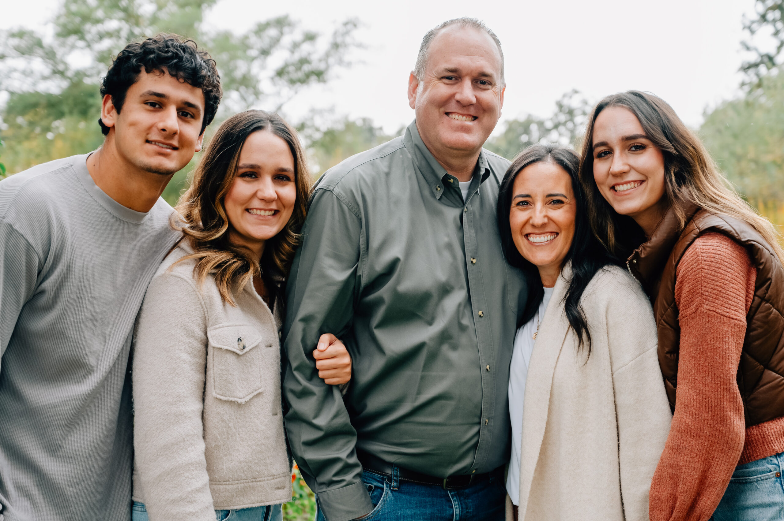 Family of five smiling together at Lodi Lake during an autumn family photography session