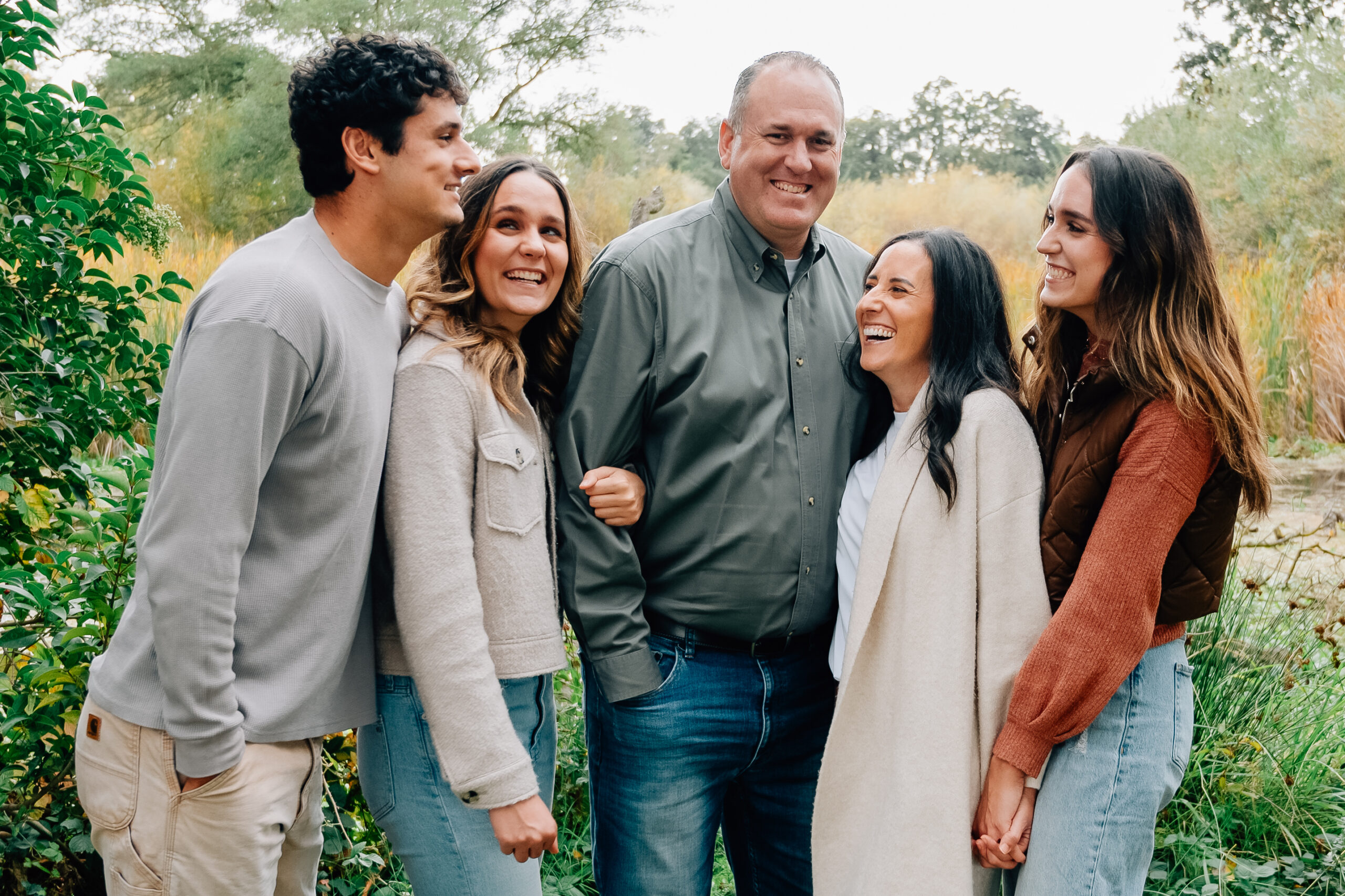 Family of five laughing together at Lodi Lake during an autumn family photography session