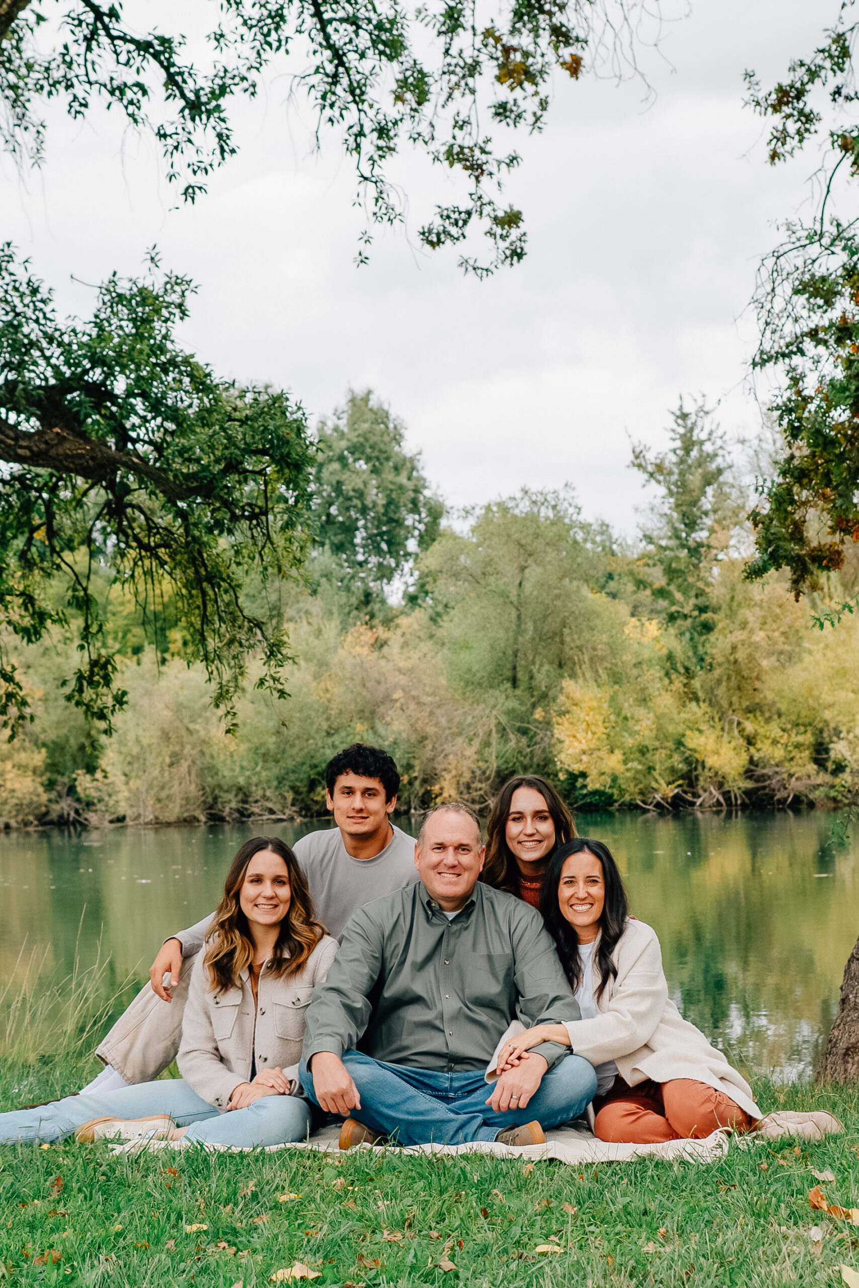 Family of five smiling together at Lodi Lake during an autumn family photography session