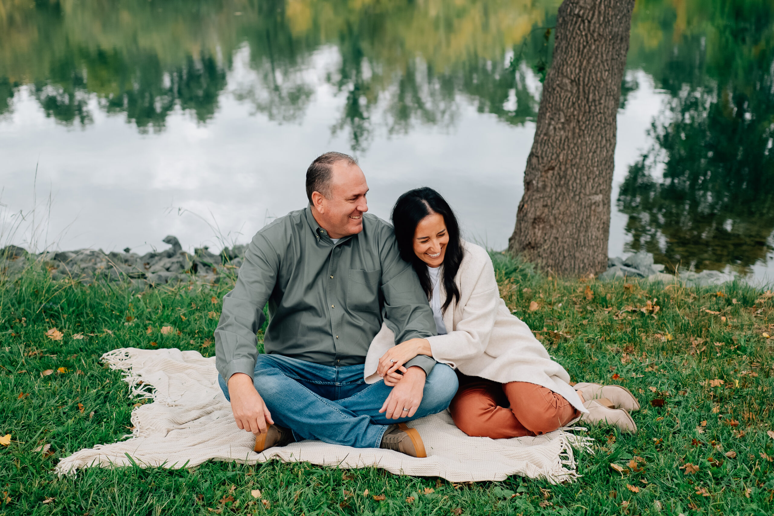 Parents laughing together during a fall family session at Lodi Lake in California