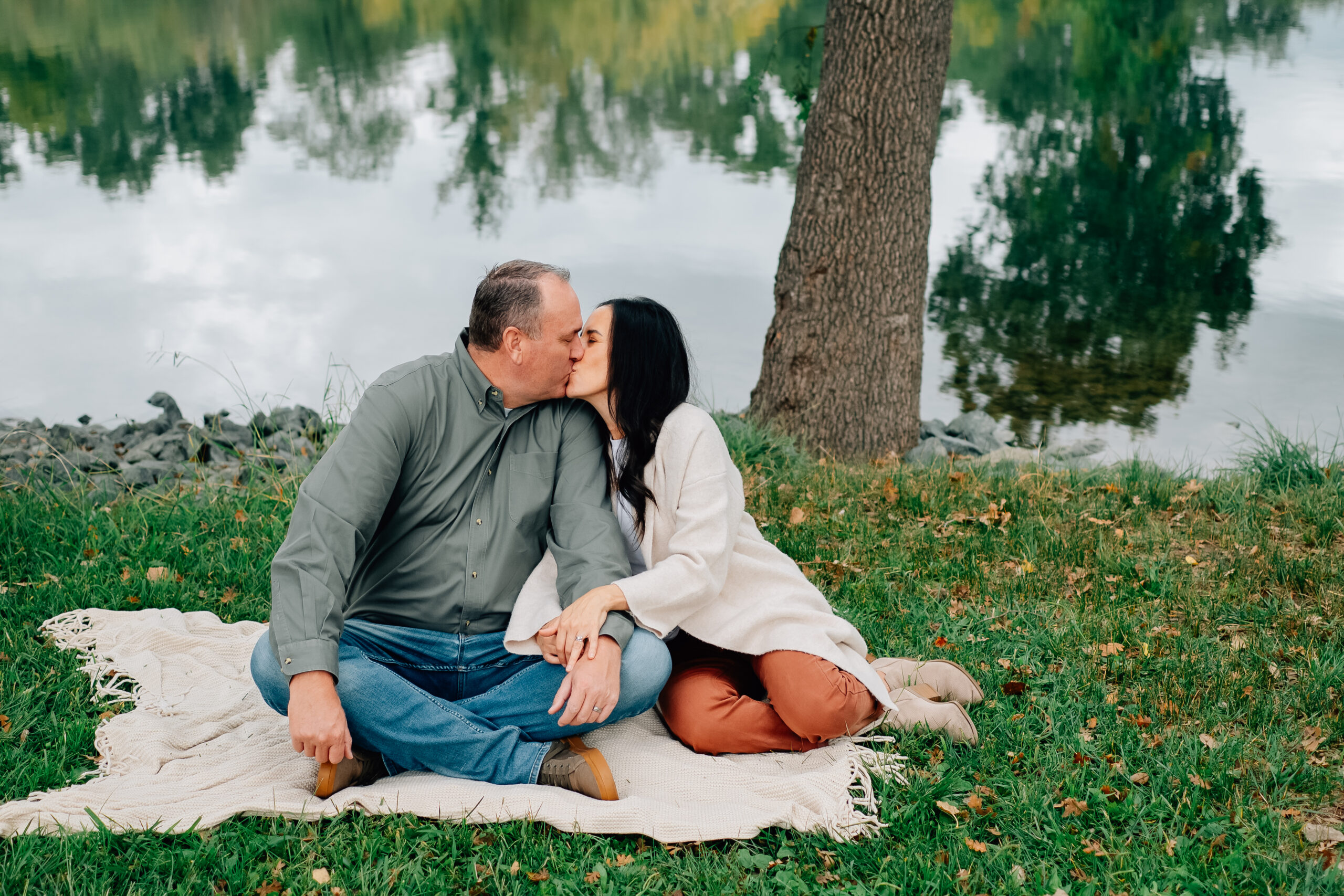 Parents stealing a kiss together during a fall family session at Lodi Lake in California