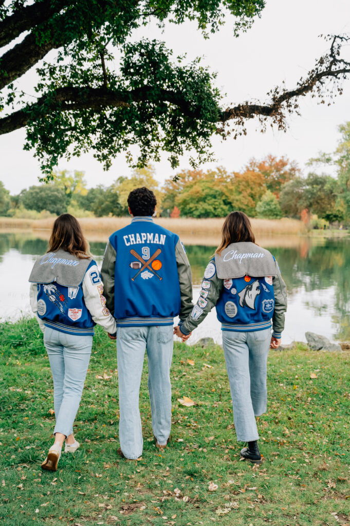 Three siblings wearing school letterman jackets during a Lodi Lake family portrait session